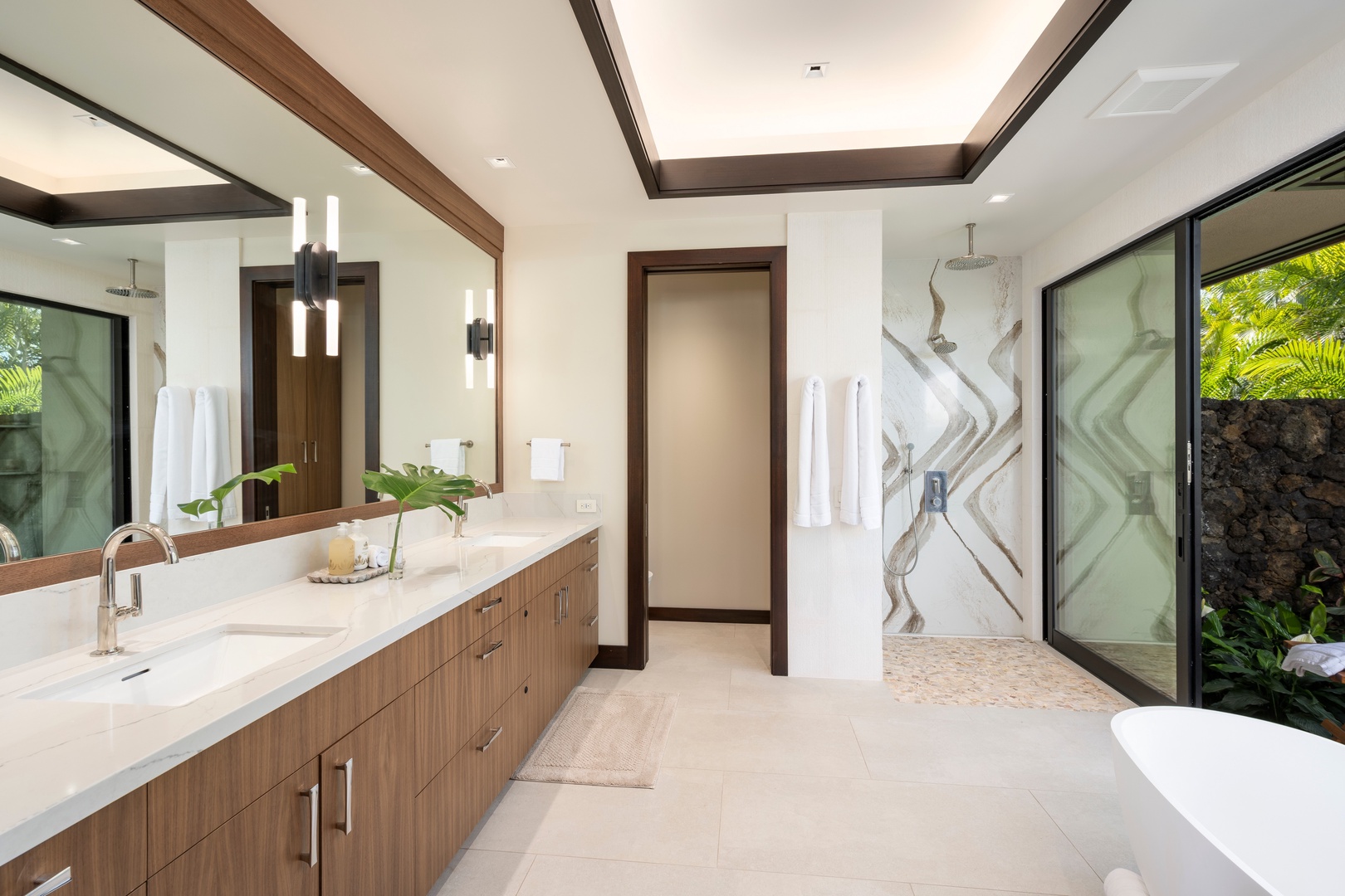 Kailua-Kona Vacation Rentals, 4BD Ka'Ulu Estate (102A) at Hualalai Resort - Primary Suite #1: Your luxurious bathroom sanctuary features dual vanities, a rainfall shower, and serene garden views through floor-to-ceiling windows.