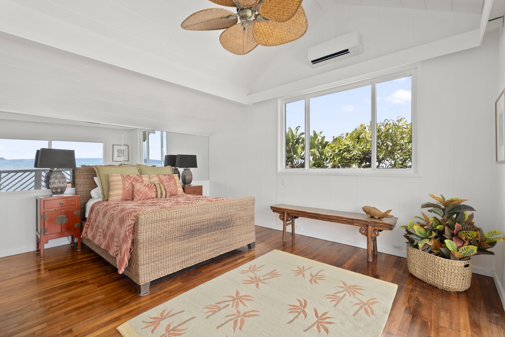 Waianae Vacation Rentals, Ma'ili Blue Estate - Unwind in your tropical primary bedroom sanctuary featuring warm coral linens and beautiful garden views through bright windows.