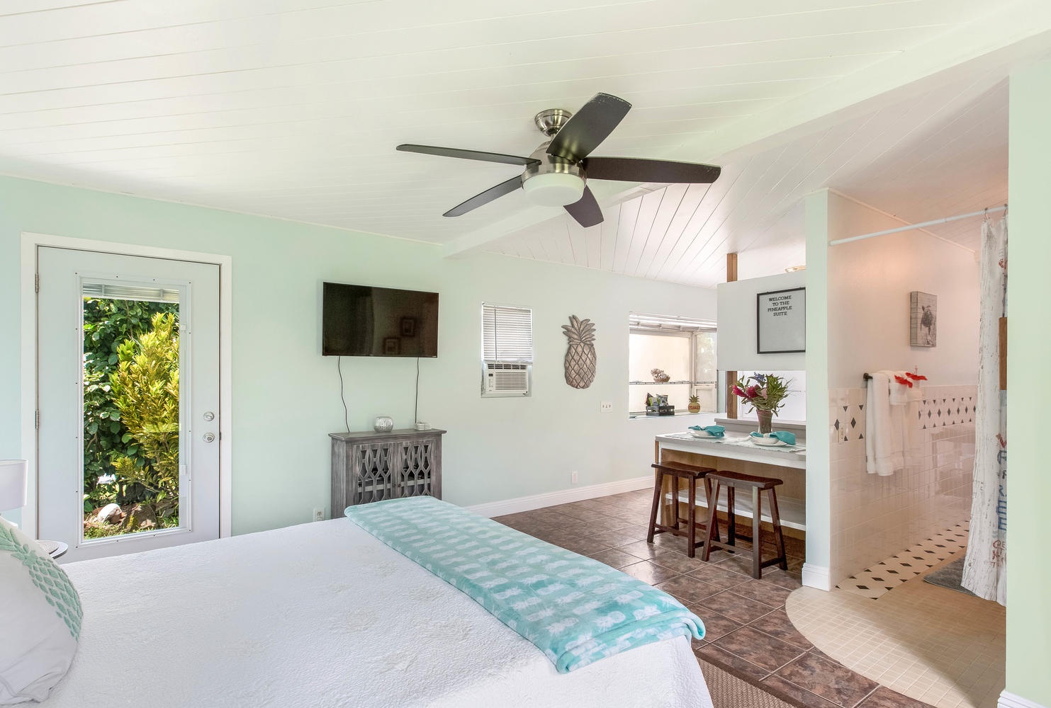 Princeville Vacation Rentals, Ola Hou - Entire Property - Stylish studio with a wall-mounted TV, a ceiling fan, and an inviting ambiance perfect for relaxing after a long day.