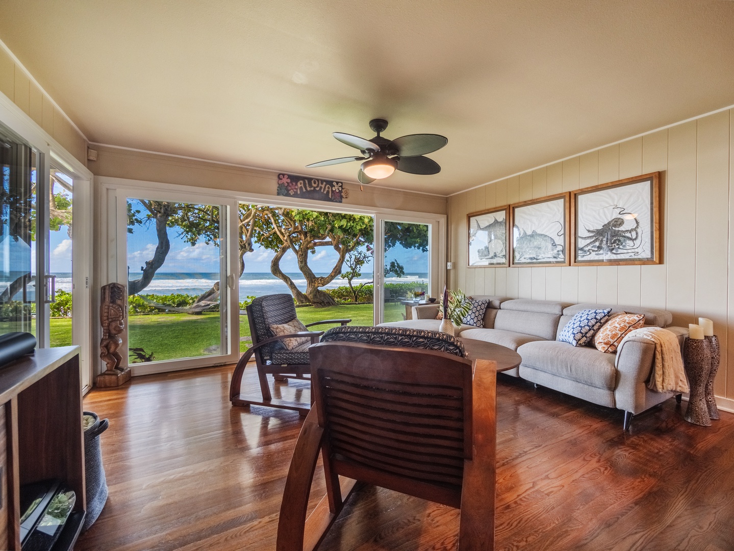 Haleiwa Vacation Rentals, Sunset Point Hawaiian Beachfront** - Step inside the living area with glass sliders for a cozy indoor-outdoor living.