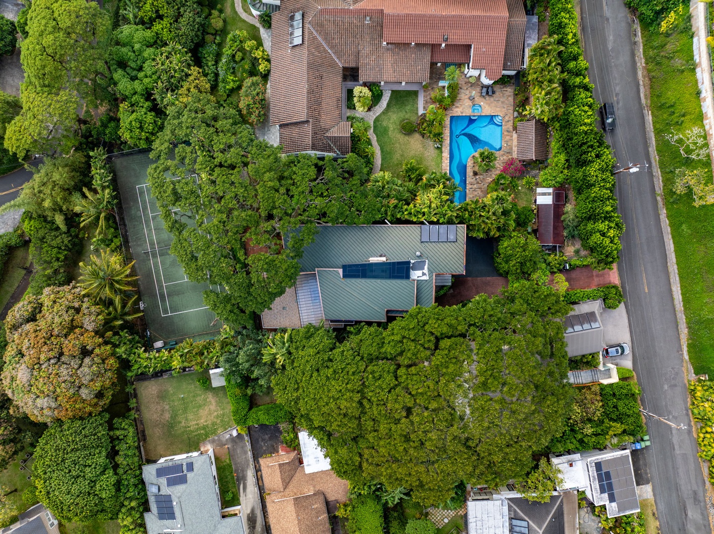 Honolulu Vacation Rentals, Tantalus Glass House - Aerial view of the home tucked into lush tropical greenery, with your private pool, pickle ball and tennis courts both included for you to enjoy.