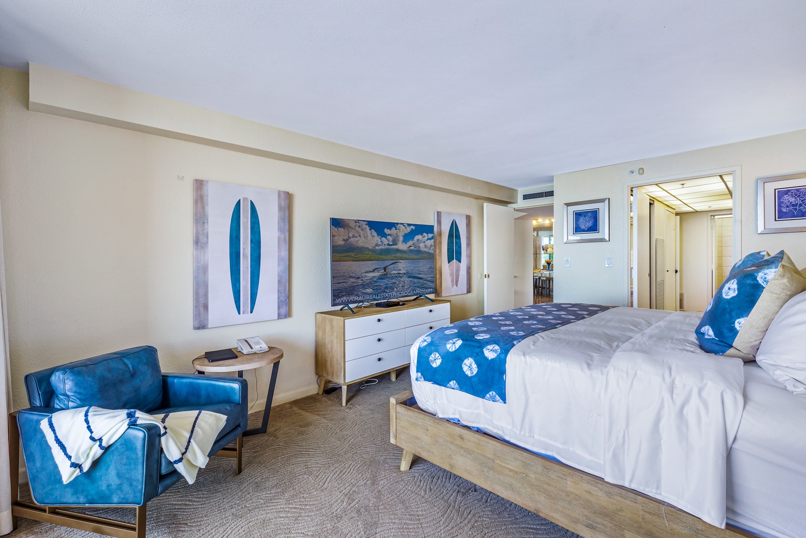 Lahaina Vacation Rentals, Kaanapali Shores 502 - The spacious primary suite offers modern coastal decor, with a comfortable seating nook perfect for quiet moments, and easy access to the nearby bathroom and living areas.