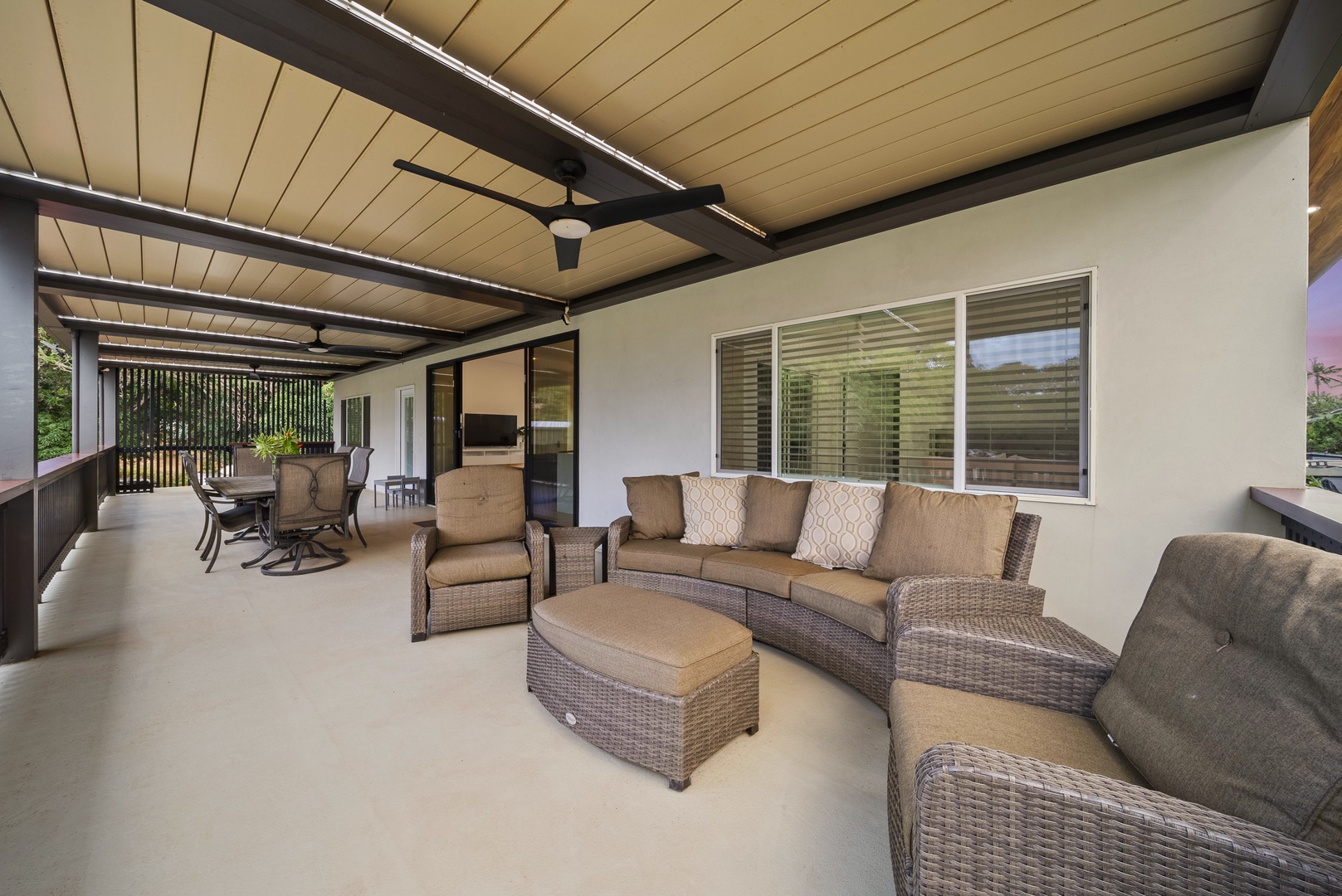 Haleiwa Vacation Rentals, Sunset Pickleball Paradise - Comfortable outdoor seating on the lanai with a ceiling fan offers a relaxing retreat for guests to unwind while enjoying the fresh air.