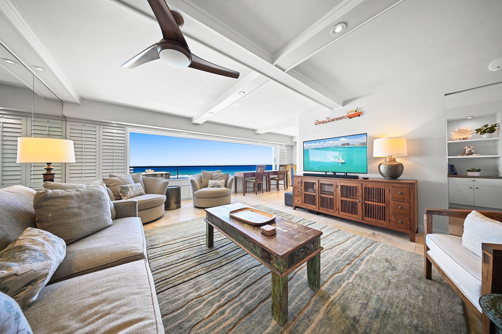 Honolulu Vacation Rentals, Kaimana Shores Getaway - Settle into the inviting living room with comfortable seating, Smart TV, and partial ocean views just beyond the windows.