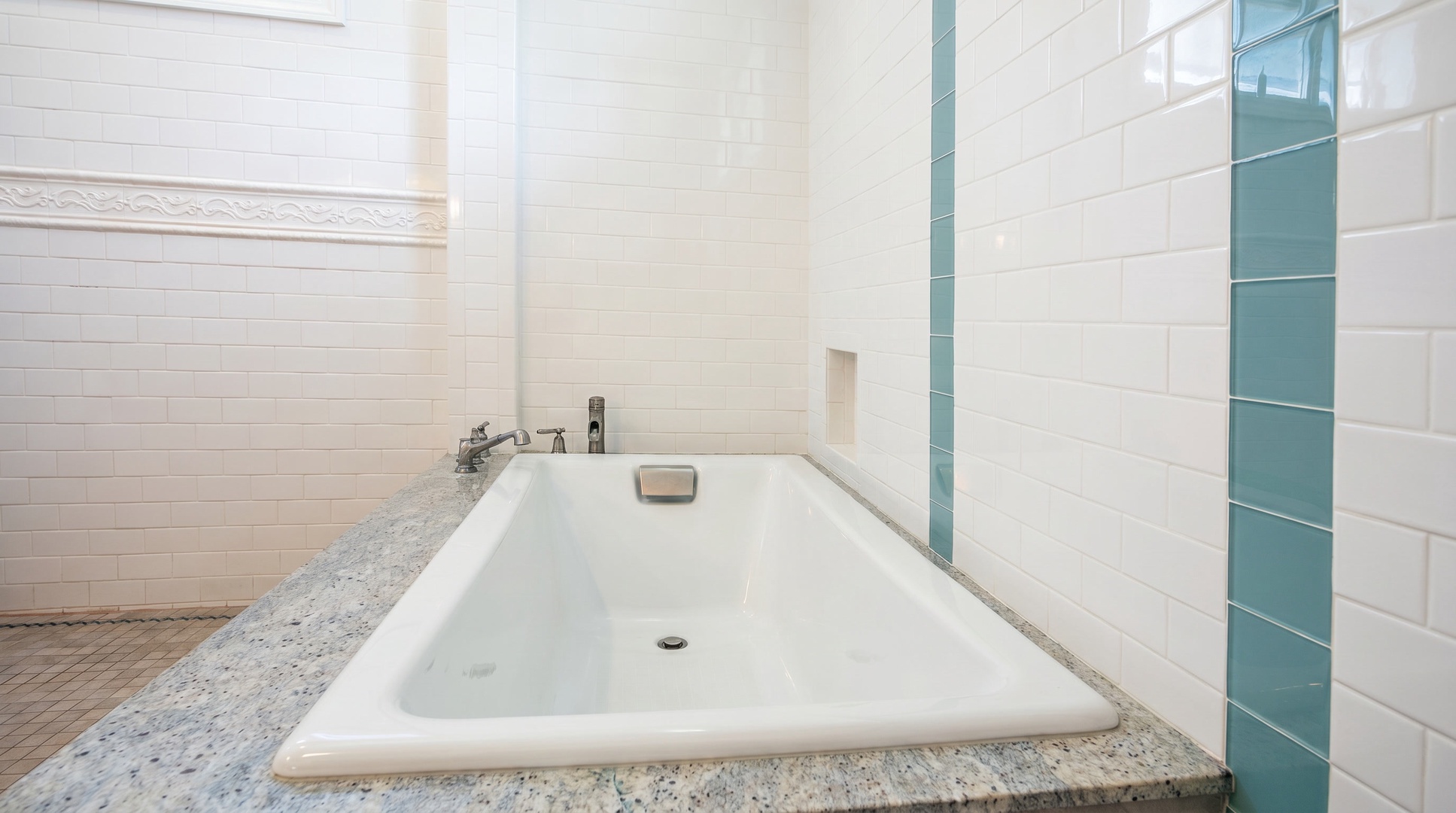 Soaking tub set in granite under a high window, for the long bath after a day in the sun.