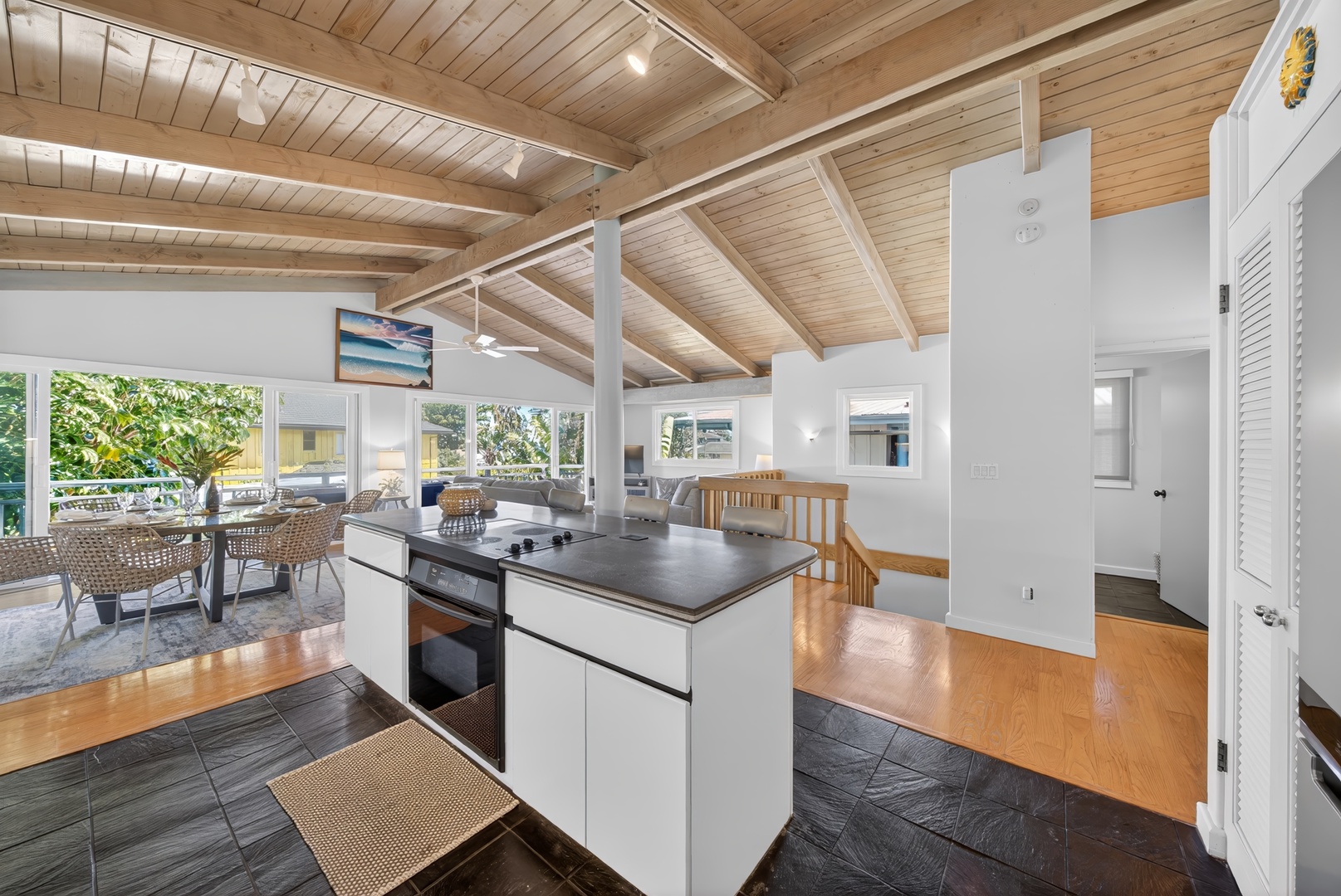 Haleiwa Vacation Rentals, Sunset Beach Hideaway - Enjoy the spacious, open-concept living area with its vaulted wood beam ceiling, natural light flooding through large windows, and cozy island for gathering.