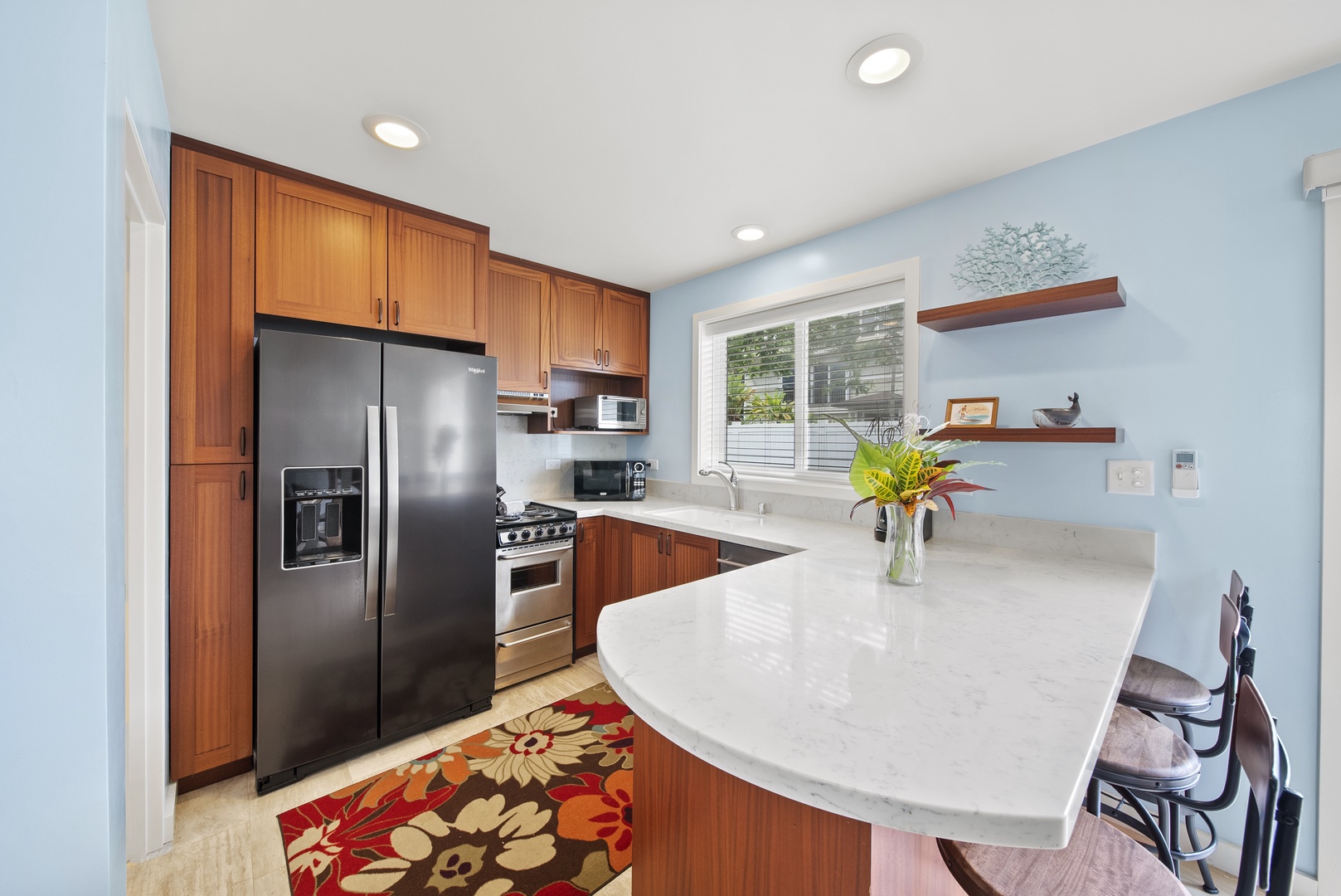 Waialua Vacation Rentals, Kala'iku Cottage - Inside the French doors you walk into a full kitchen with an apartment sized stove and refrigerator, custom cabinetry, and stone countertops