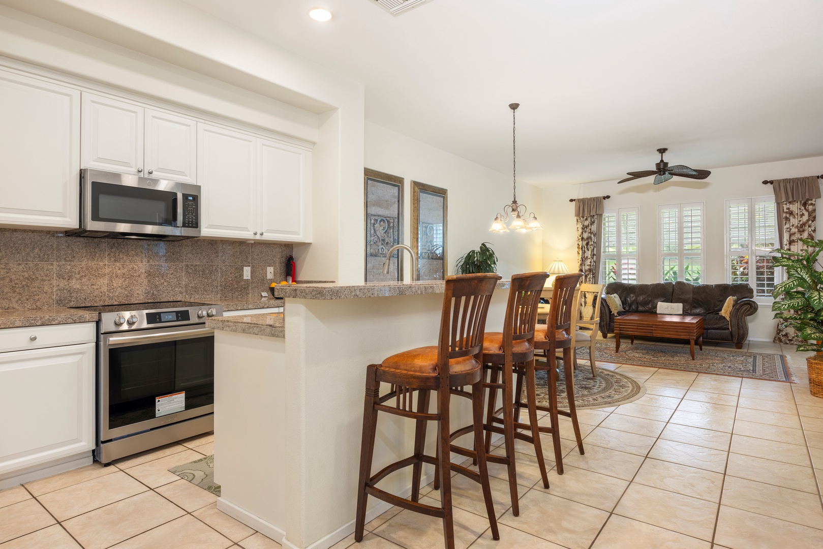 Kapolei Vacation Rentals, Coconut Plantation 1150-2 - Enjoy cooking in your fully equipped kitchen with granite countertops and breakfast bar seating overlooking the comfortable living area.