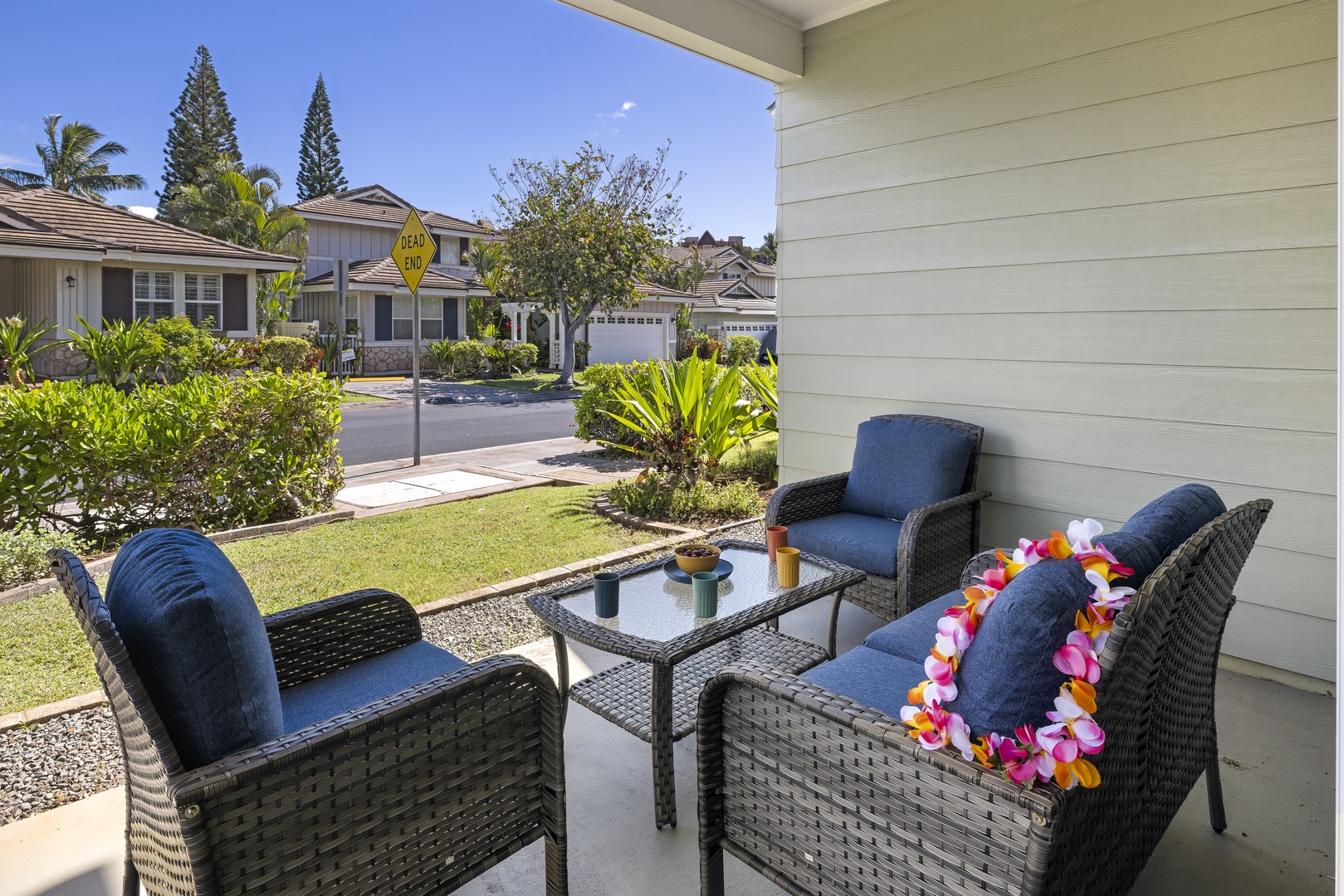 Start your day on the covered lanai, where comfortable seating and tropical landscaping create a peaceful outdoor retreat.