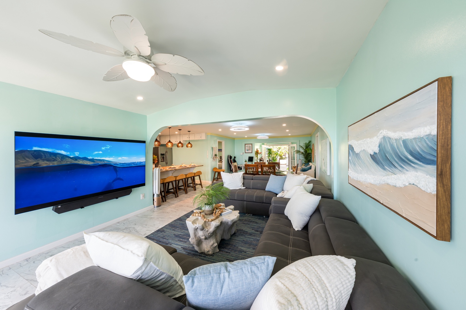 Hauula Vacation Rentals, Private Beach Paradise - Plush sectional seating with ocean-inspired decor and a large flat screen for relaxing nights.
