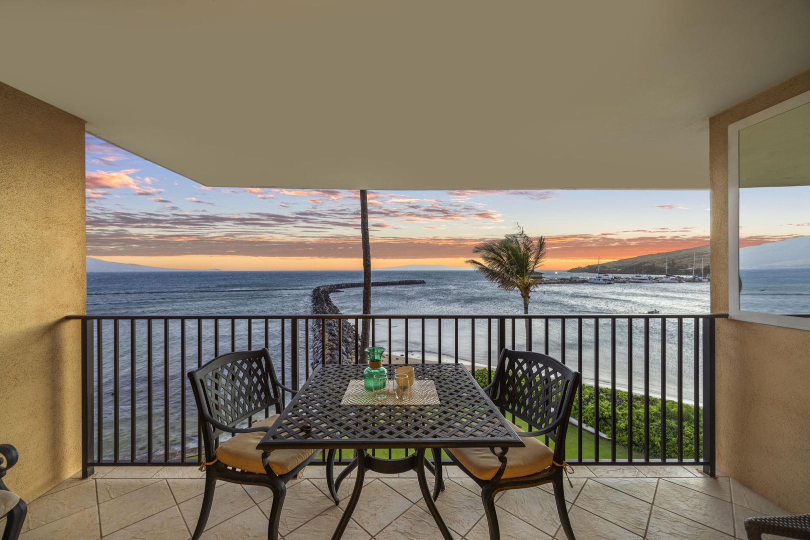 Wailuku Vacation Rentals, Milowai 310 - Sunset burns pink and orange over the jetty, right where the lanai table is already set for two.