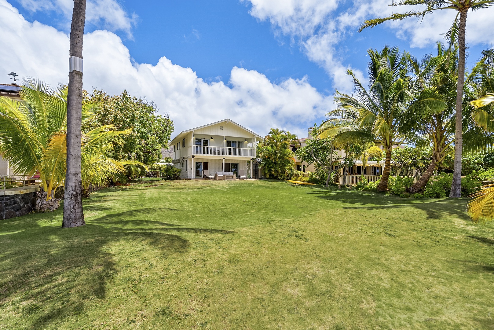 Honolulu Vacation Rentals, Honolulu Beachfront Retreat - Expansive backyard surrounded by lush tropical landscaping, perfect for outdoor activities and relaxation.