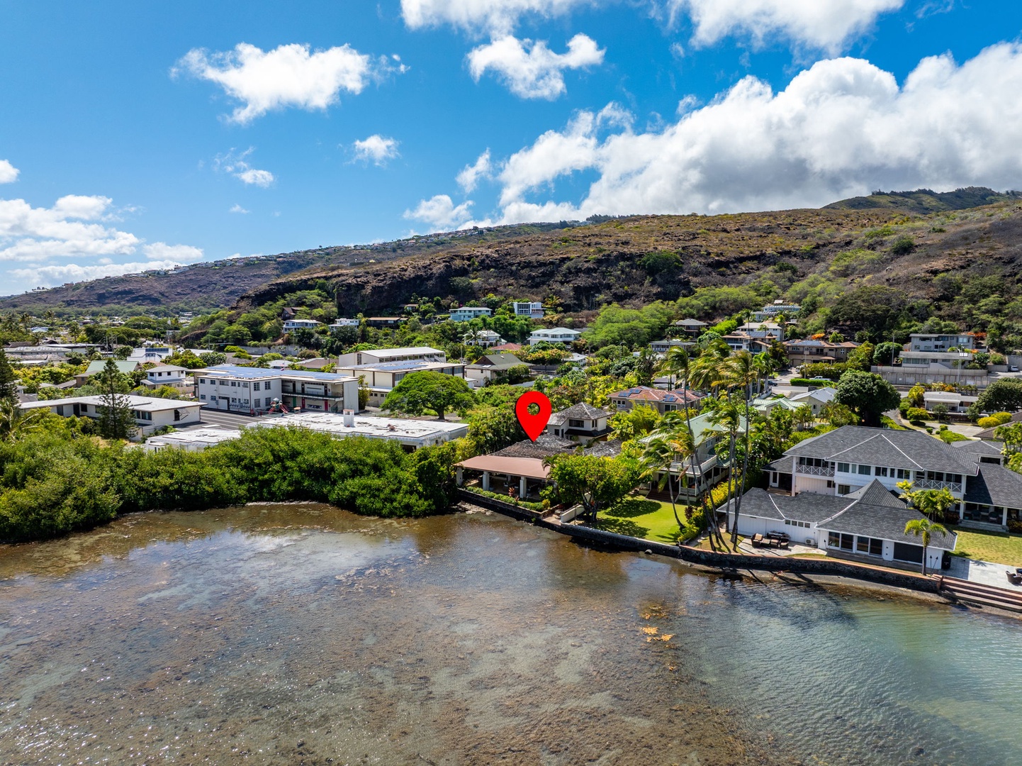 Honolulu Vacation Rentals, The Lagoon House 3BR - Aerial view of the waterfront home set along calm bay waters with hillside backdrop.