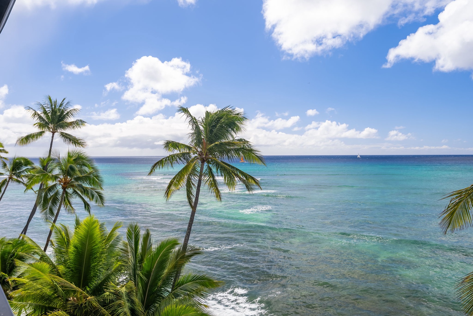 Honolulu Vacation Rentals, Kaimana Beach Penthouse - Breathtaking view of turquoise waters and palm trees, perfect for enjoying tropical breezes and sunshine.