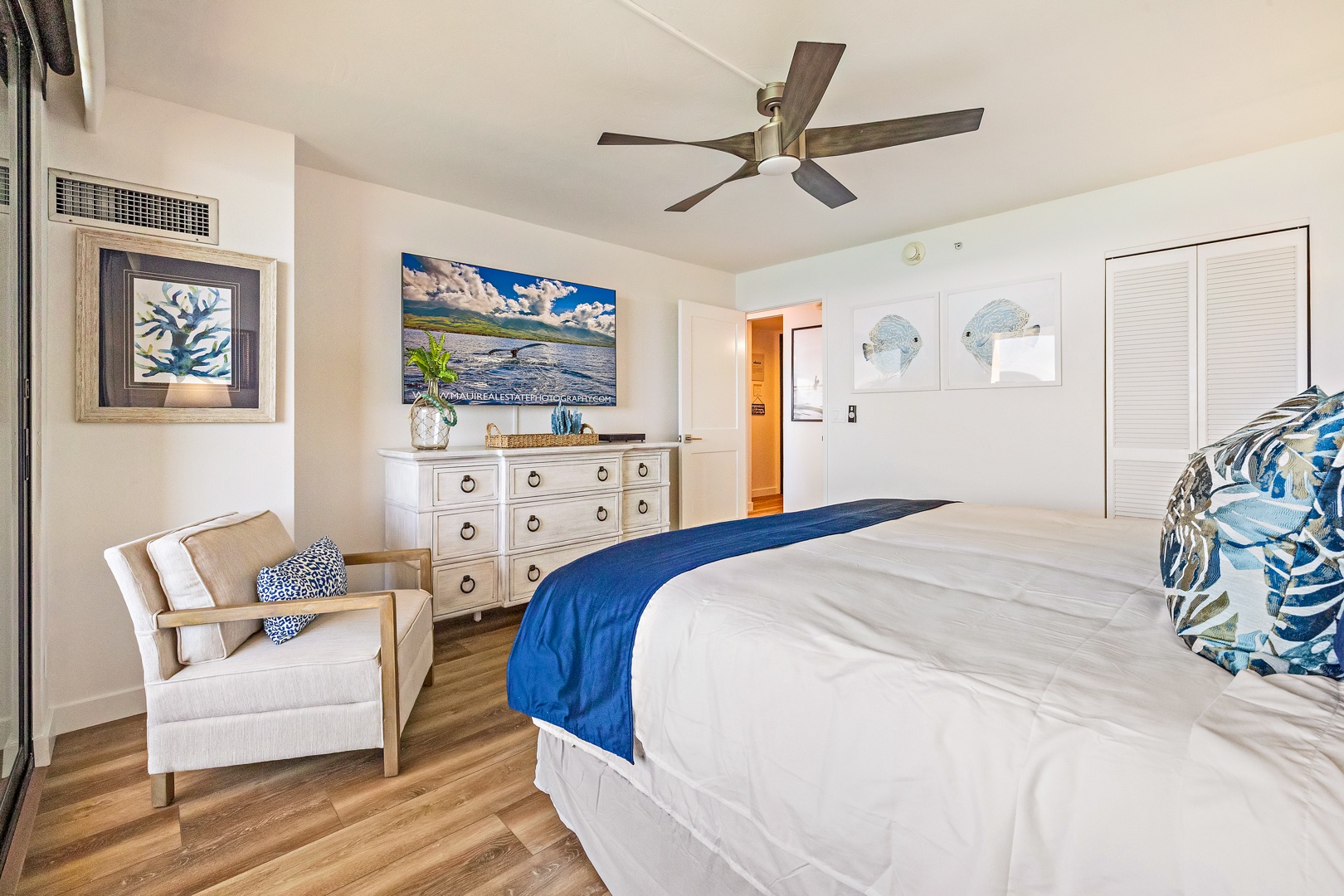 Lahaina Vacation Rentals, Mahana 1118 - he spacious primary bedroom offers a serene atmosphere with a modern ceiling fan, comfortable seating area, and coastal décor