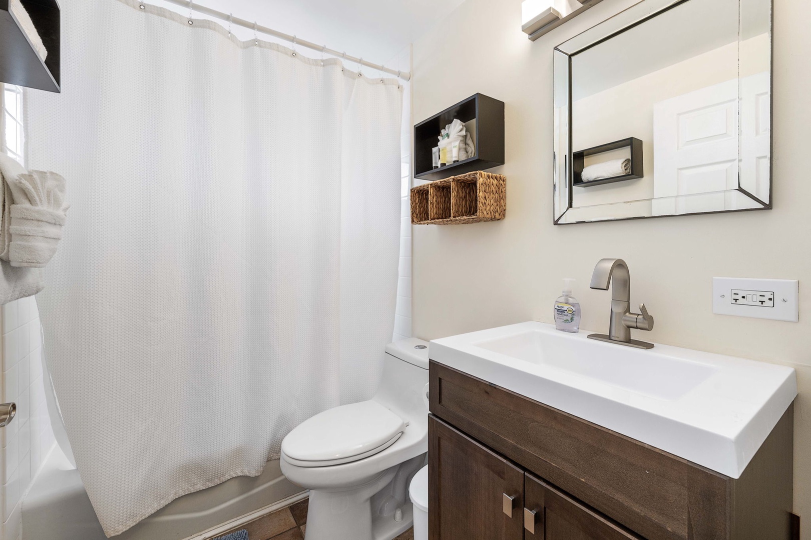 Kailua Kona Vacation Rentals, Kona Plaza 201 - Primary bathroom with a tub/shower combo, ideal for unwinding after a day of exploring.