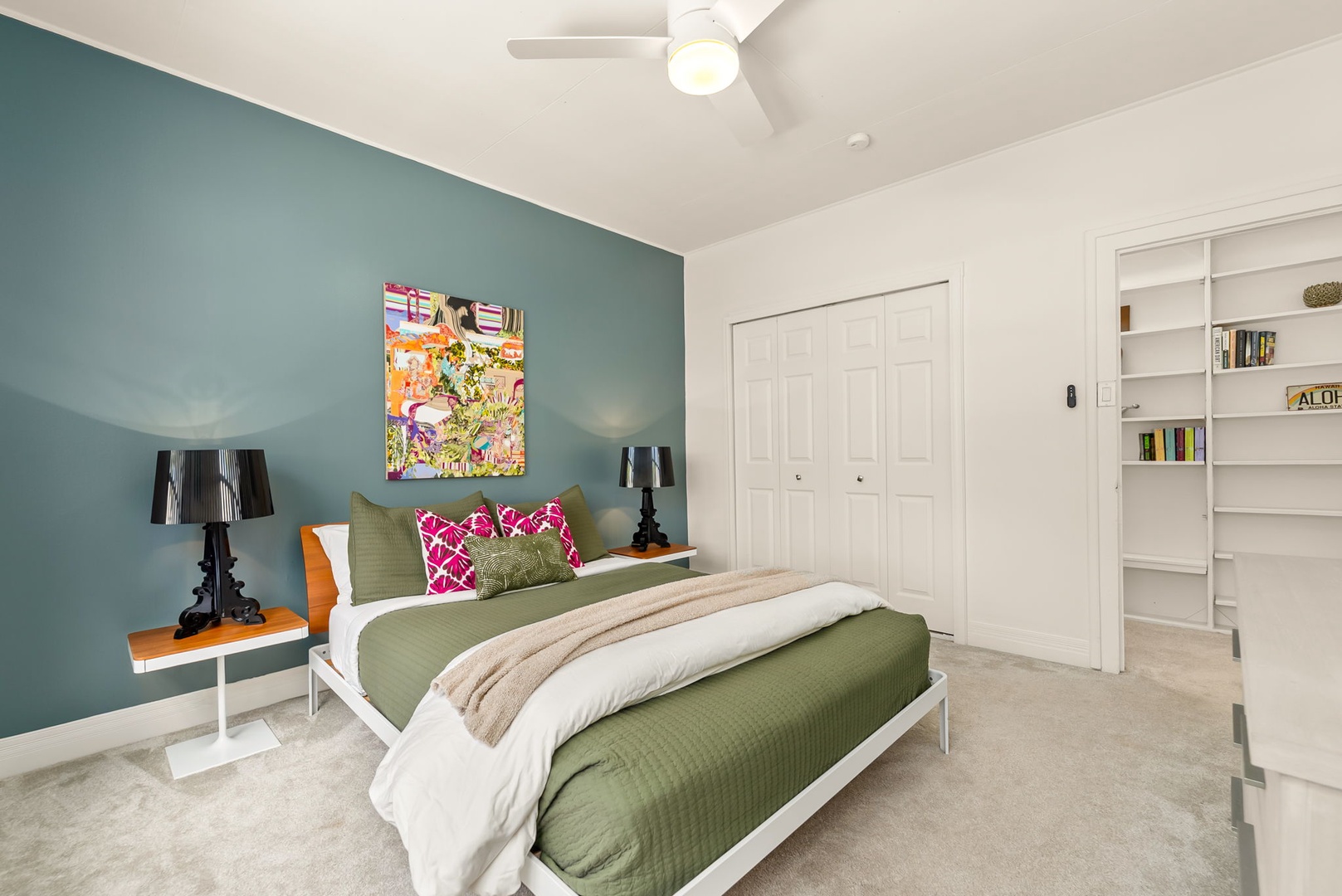 Honolulu Vacation Rentals, Ho'okipa Villa - Your calm retreat features a soothing teal accent wall, plush bedding with vibrant accents, modern lighting, and a built-in bookshelf for your favorite reads.