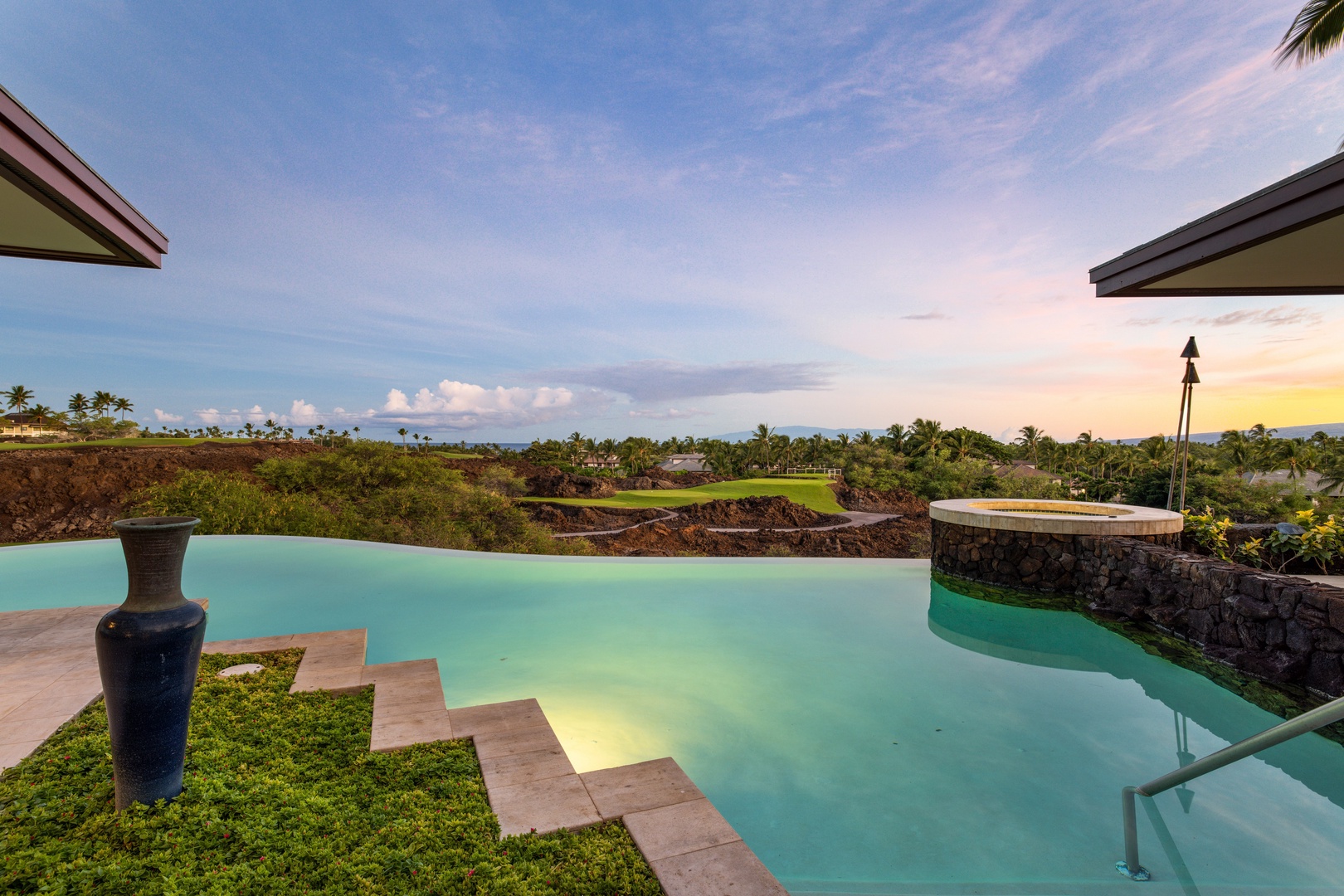 Kamuela Vacation Rentals, Champion Ridge 7 - Soft twilight skies reflect off the serene pool, framed by lava rock and tropical greens.
