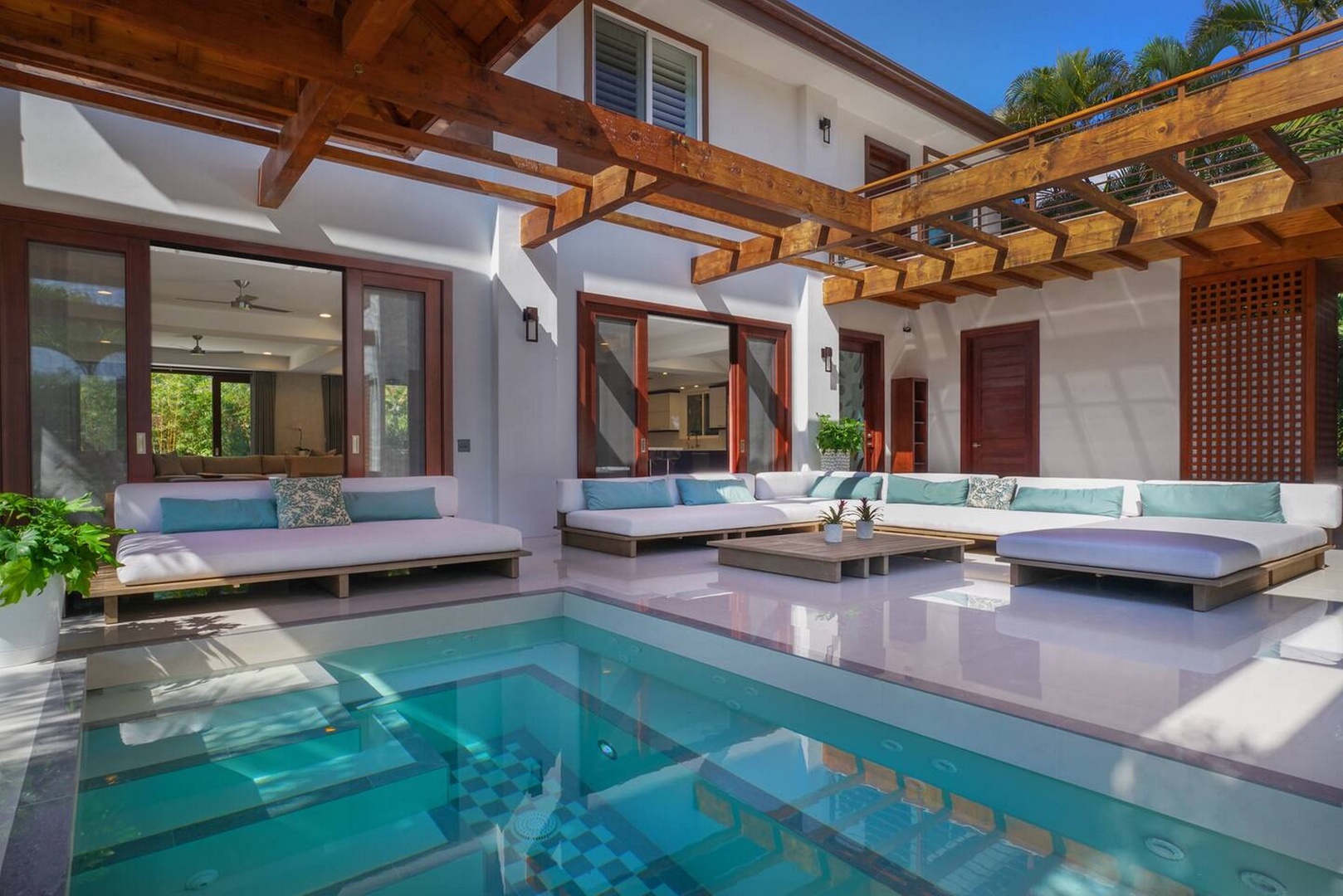 Honolulu Vacation Rentals, Diamond Head Beachfront Estate 9BR - The pool's turquoise edge meets the open-air living room, indoors and out blurred together.