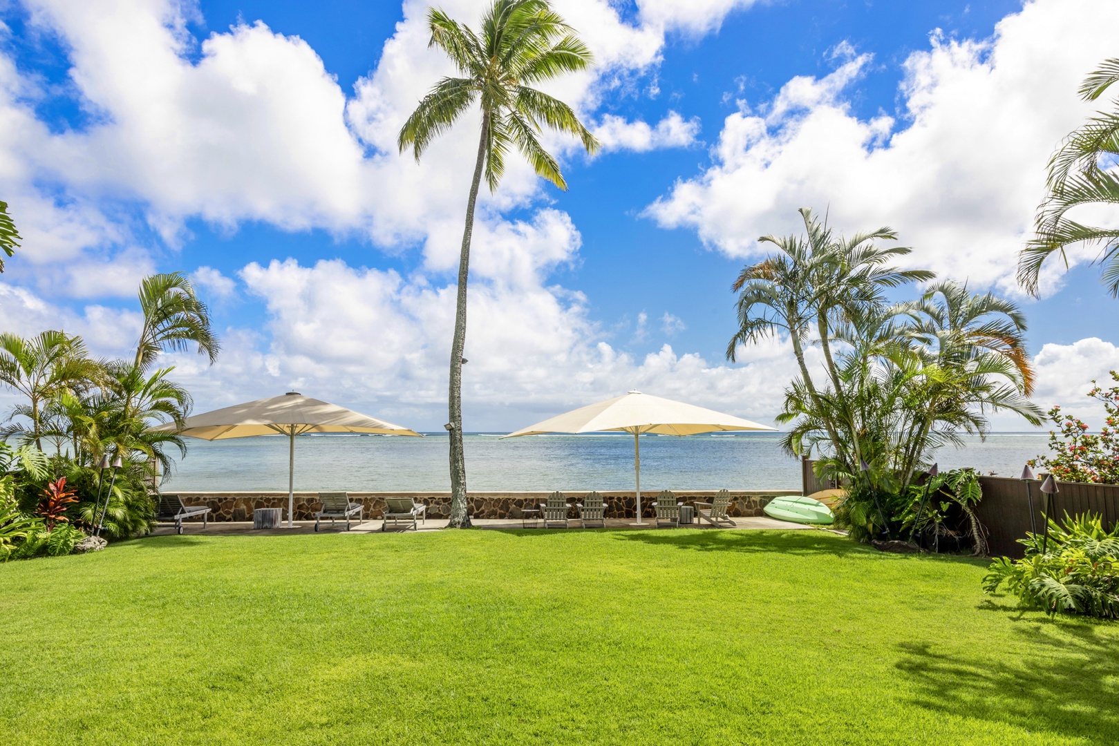 Honolulu Vacation Rentals, Moana Lani - Main House - Out on the grass, shade umbrellas mark the spot where the lawn meets the ocean.