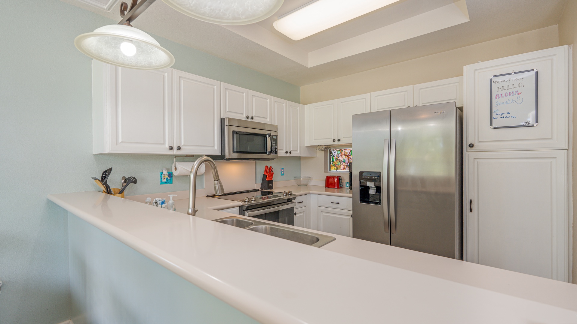 Kapolei Vacation Rentals, Fairways at Ko Olina 8G - Features pristine white cabinets, stainless steel appliances, and a spacious breakfast bar perfect for morning coffee or meal prep.