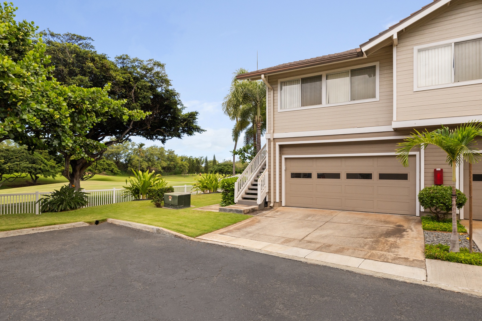 Kapolei Vacation Rentals, Fairways at Ko Olina 7A - Modern two-story property with garage and tropical landscaping in a peaceful residential setting.