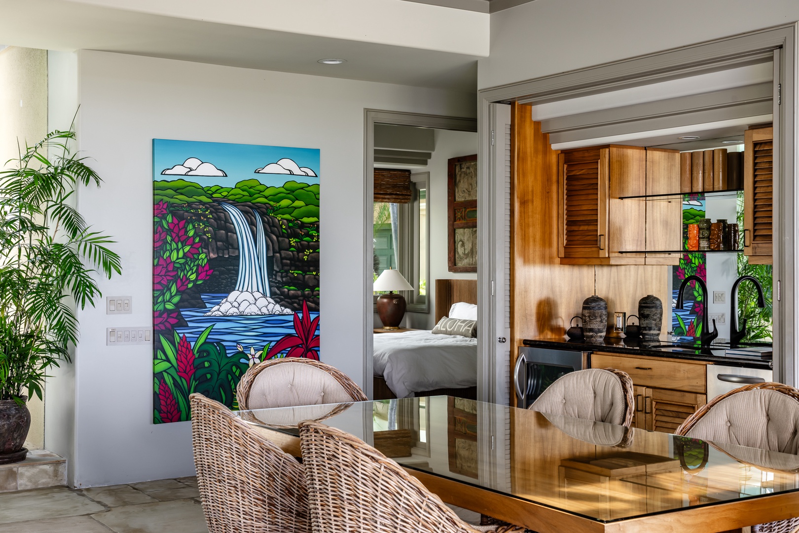 Kamuela Vacation Rentals, Canoe House at Champion Ridge - Bright dining area with tropical artwork and a view into the cozy bedroom.