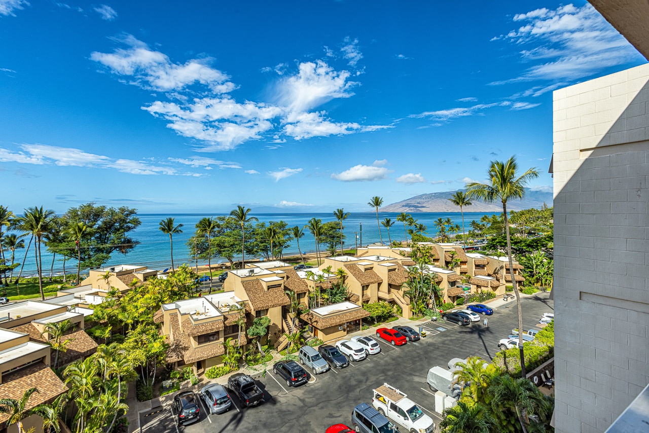 Kihei Vacation Rentals, Kamaole Beach Royal 610 - Rooftops and palm crowns fill the space between this lanai and the water.