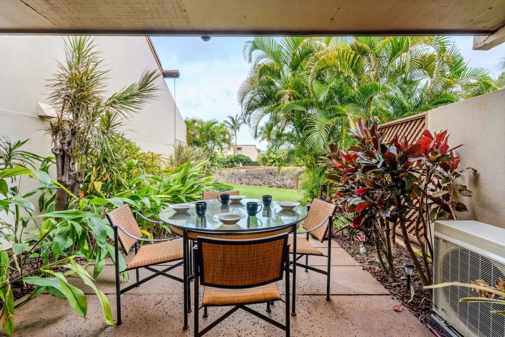 Kihei Vacation Rentals, Maui Kamaole E103 - Breakfast moves outside here, bowls and cups already on the table under the palms.