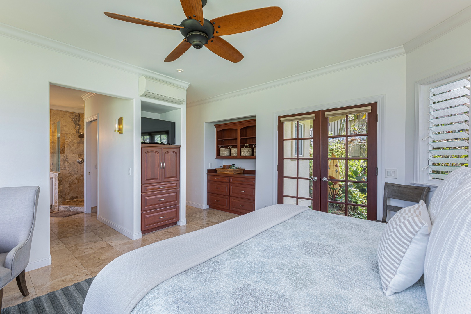 Princeville Vacation Rentals, Ohana Kamalani - Bright king bedroom with direct outdoor access, ceiling fan, and ample natural light for a breezy island feel.