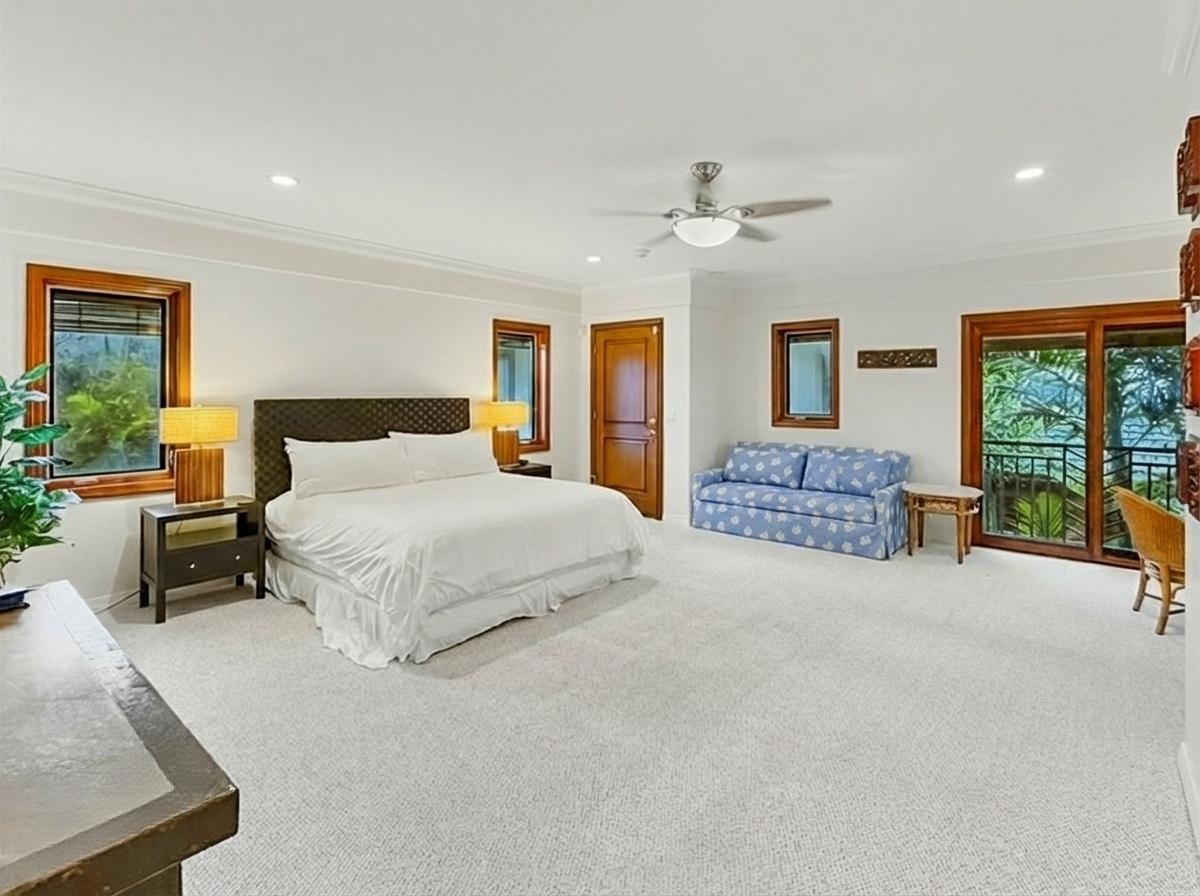 Honolulu Vacation Rentals, Maunalua Estate - Unwind in your spacious cottage featuring a plush king bed, cozy seating area, and serene garden views through elegant French doors.