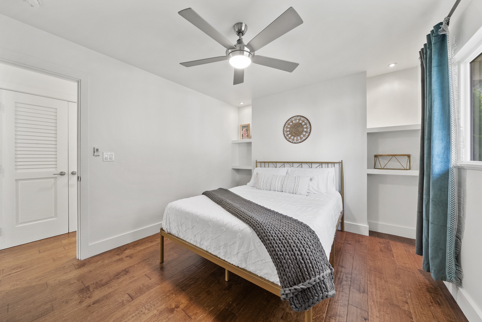 Kaaawa Vacation Rentals, Ka'a'awa Hale - Modern bedroom with sleek design, hardwood floors, and built-in shelving.