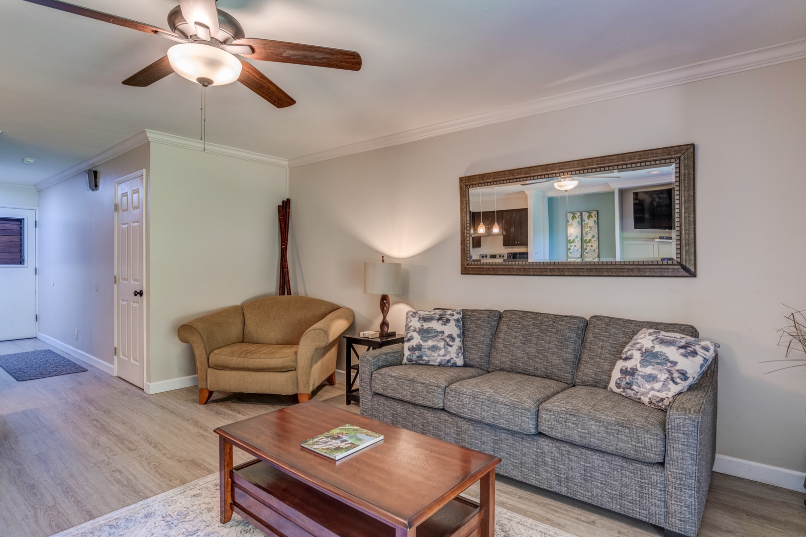 Kihei Vacation Rentals, Koa Resort 1B - Comfortable living area with a ceiling fan, sleeper sofa, and views of the tropical garden outside.