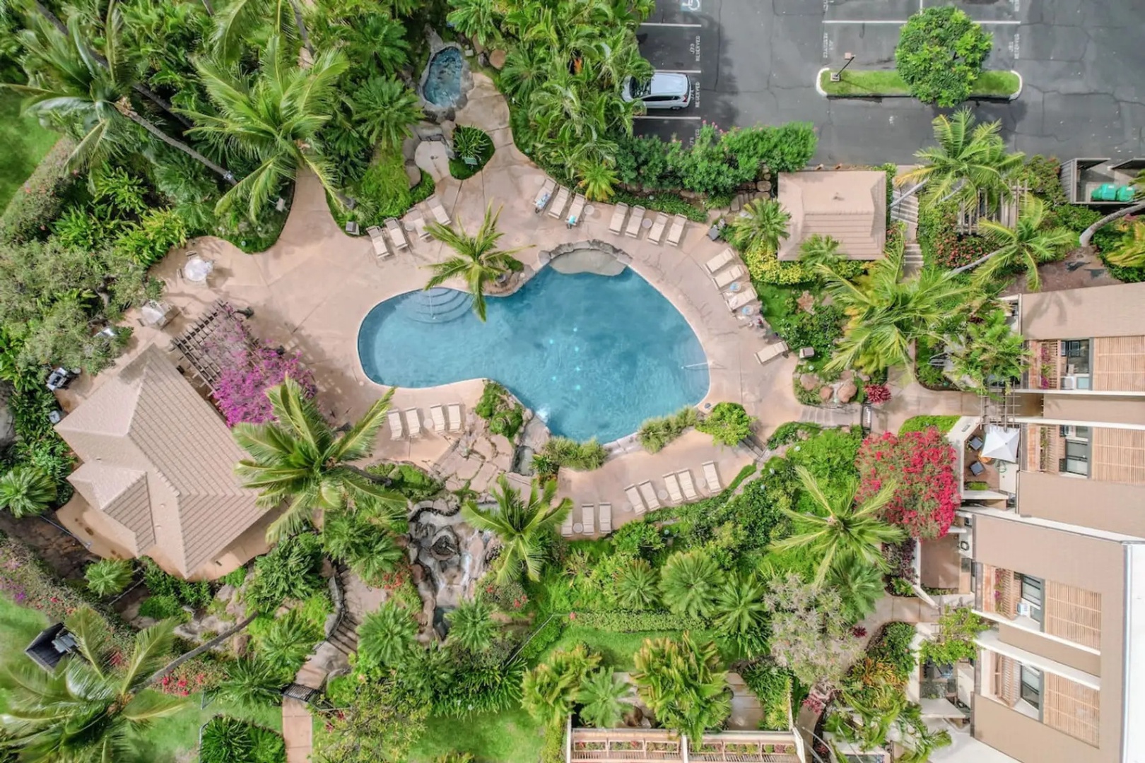 Kihei Vacation Rentals, Maui Kamaole E103 - Look down on the waterfall pool and its rock grotto, jacuzzi tucked just beside it, from above.