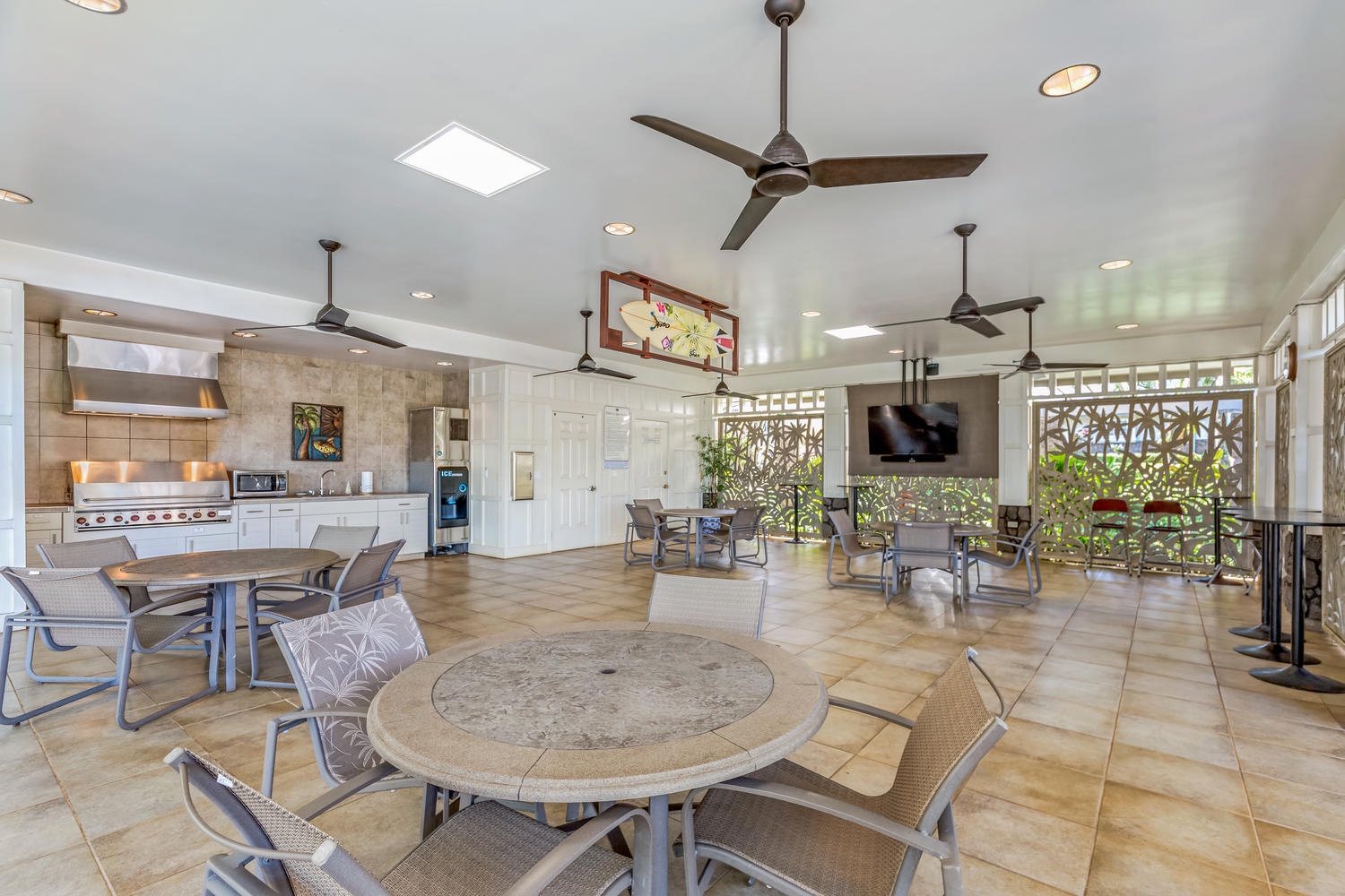 Princeville Vacation Rentals, Noelani Kai - Ceiling fans and a skylight keep the community clubhouse bright, round tables set for cards or coffee.