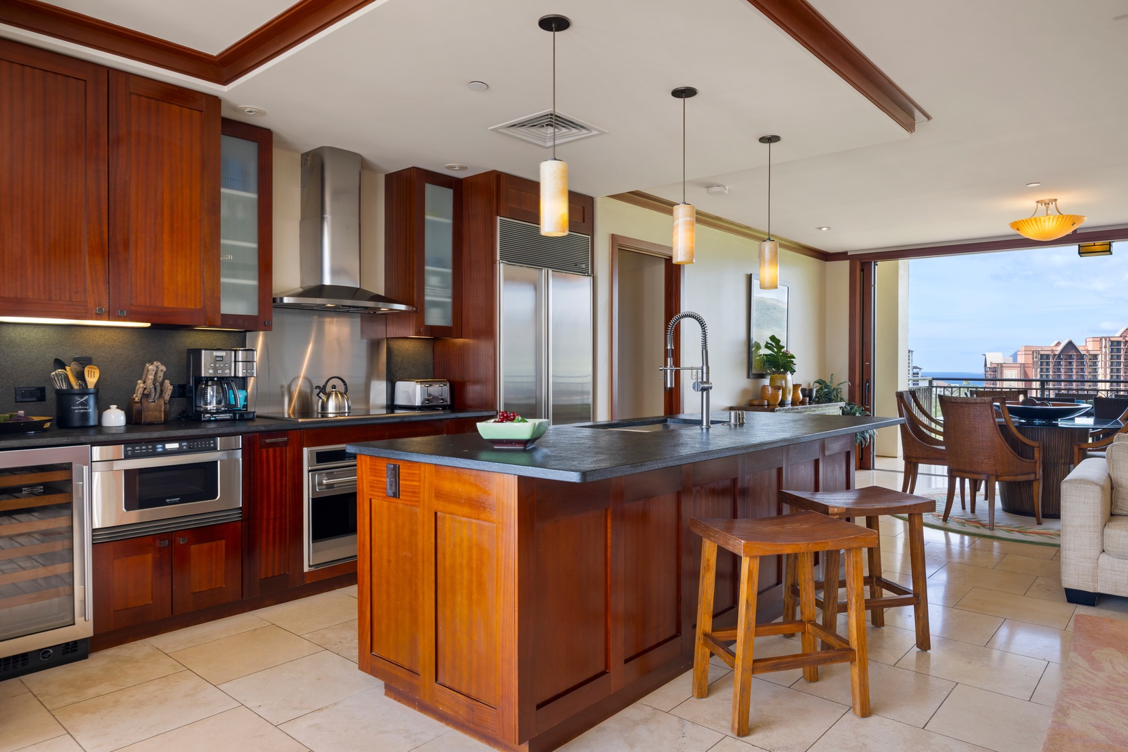 Kapolei Vacation Rentals, Ko Olina Beach Villas O1111 - Your gourmet kitchen awaits with rich wood cabinets, granite counters, and stunning city views through floor-to-ceiling windows.