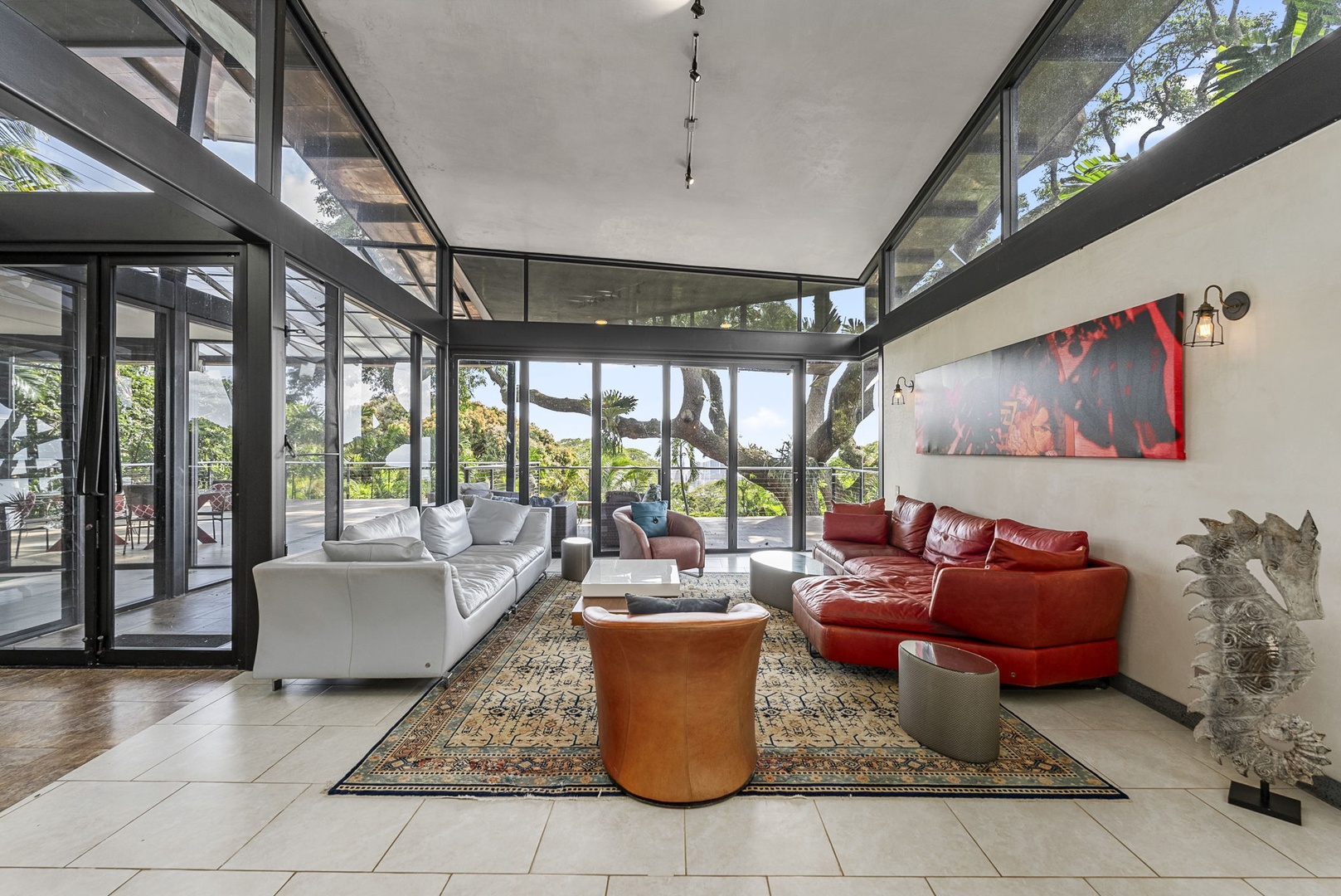 Honolulu Vacation Rentals, Tantalus Glass House (3 BD) - Unwind in this stunning glass-walled living space where floor-to-ceiling windows frame tropical views and luxurious seating invites relaxation.