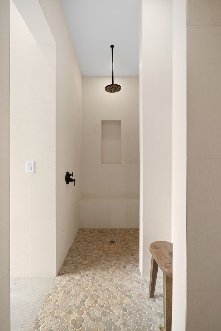 Koloa Vacation Rentals, Makani Kai - A walk-in shower finished in warm stone tile, quiet and clean-lined.