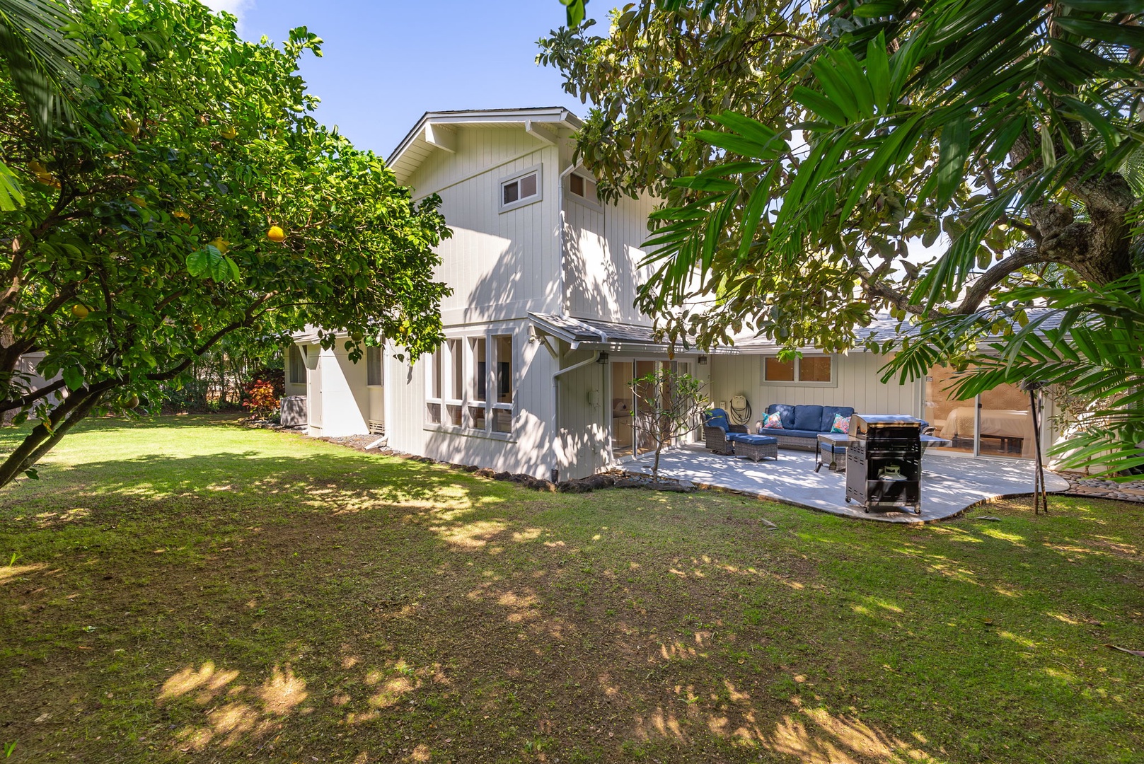 Kailua Vacation Rentals, Nohie Lanikai - Enjoy the shade of lush trees while relaxing in this spacious backyard lounge area.