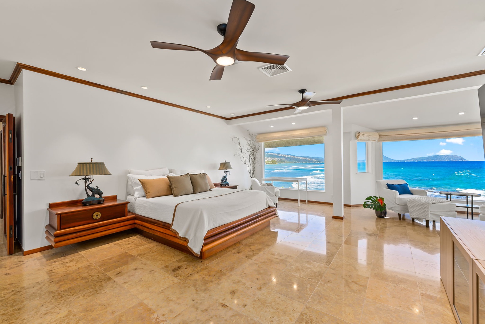 Honolulu Vacation Rentals, Black Point Ocean Villa - Wake up to breathtaking ocean views in your luxurious primary bedroom with polished floors and tropical ceiling fans.