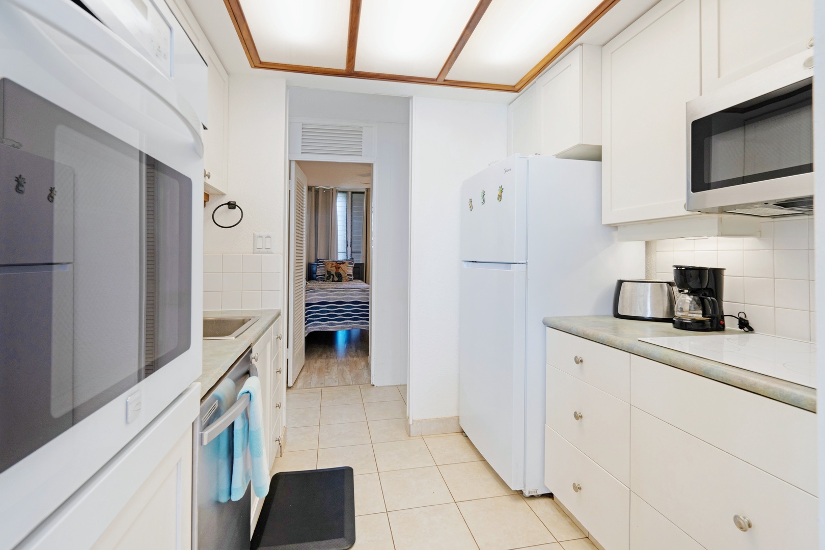 Kihei Vacation Rentals, Punahoa Beach 205 - A tidy galley kitchen keeps snacks close, with the bedroom just a few steps beyond.