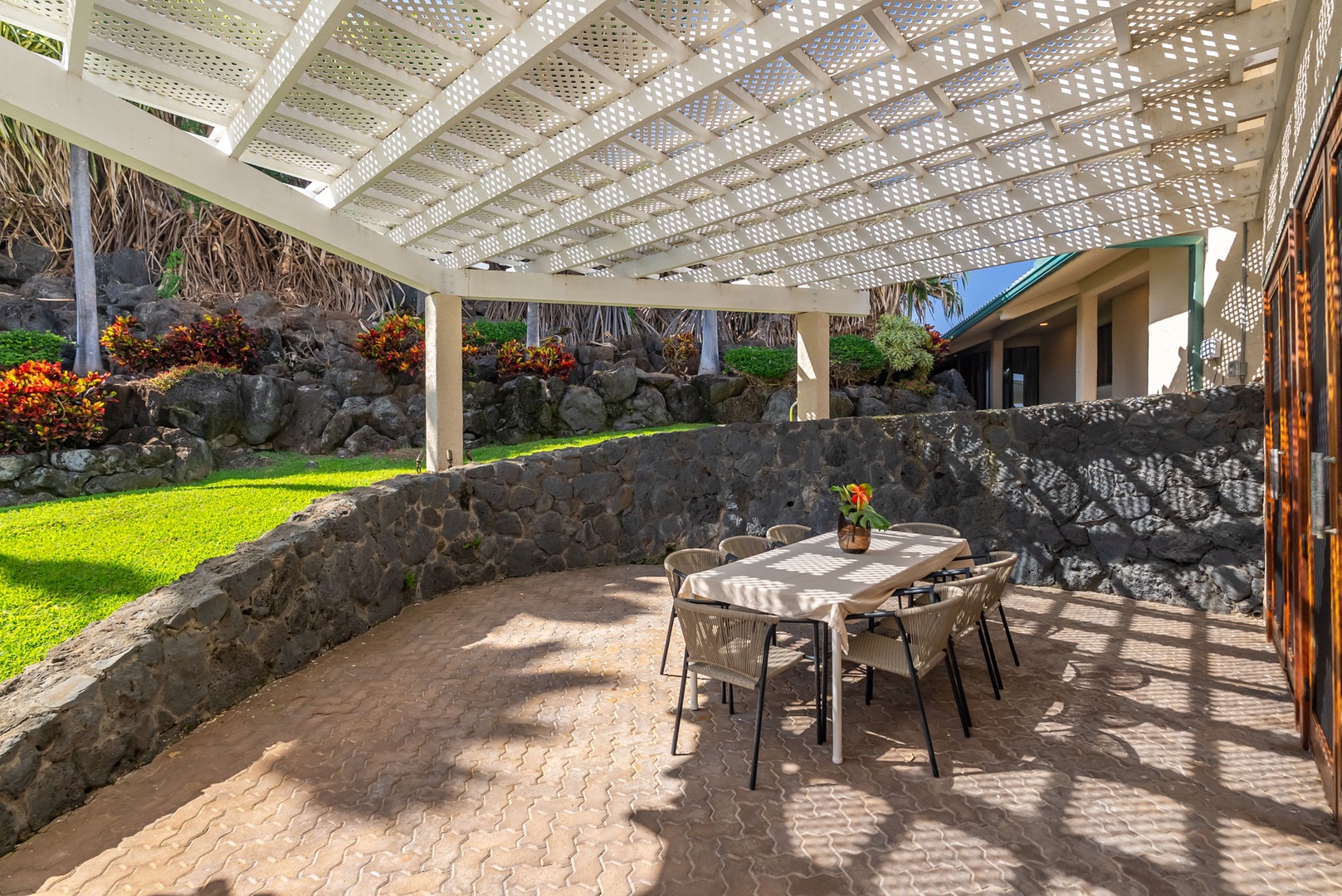 Honolulu Vacation Rentals, Black Point Ocean Villa - Your private lanai offers shaded dining surrounded by volcanic rock walls and vibrant tropical landscaping.