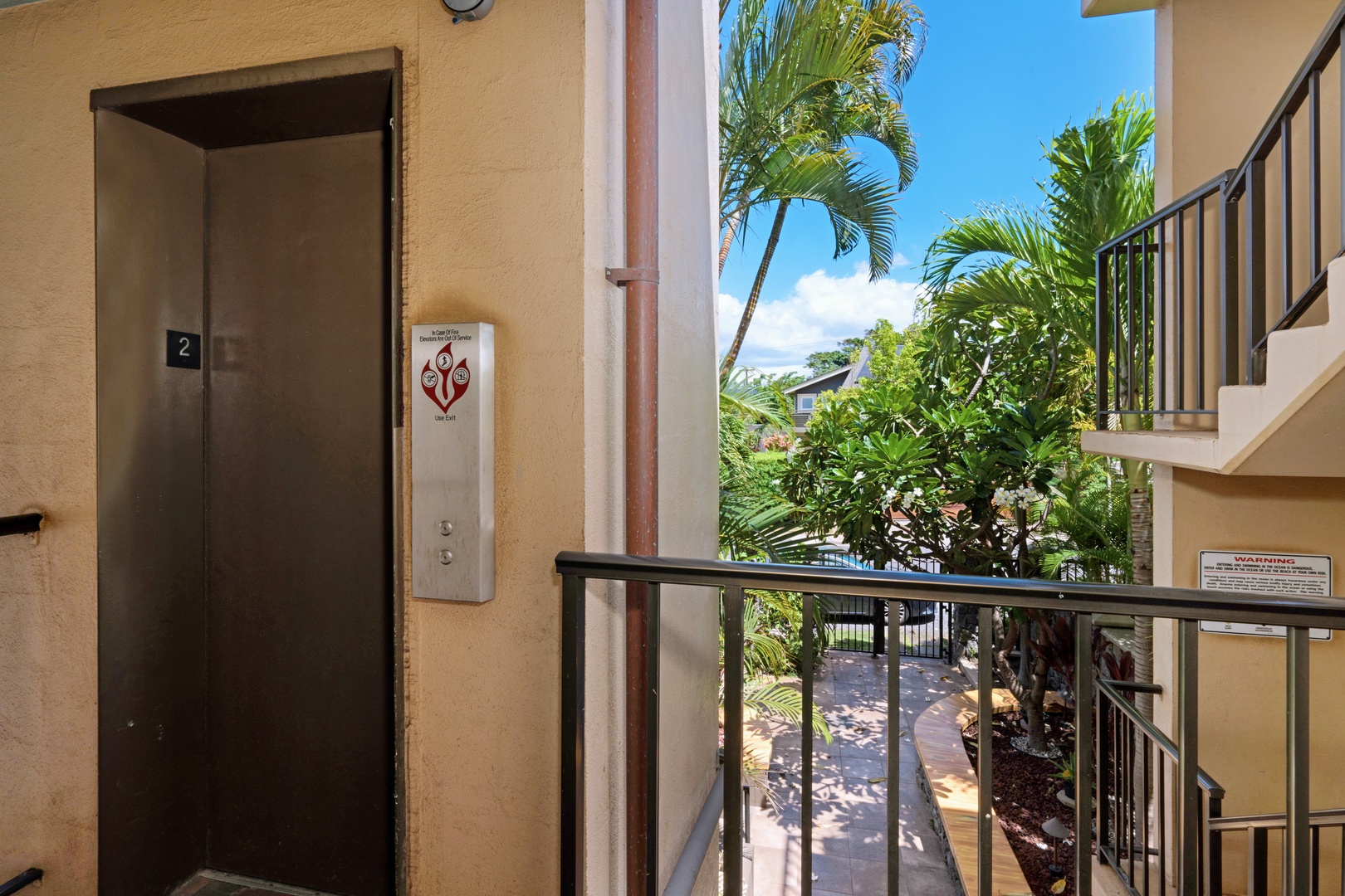 Kihei Vacation Rentals, Punahoa Beach 205 - Step off the elevator on the second floor and palm fronds already frame the sky outside.