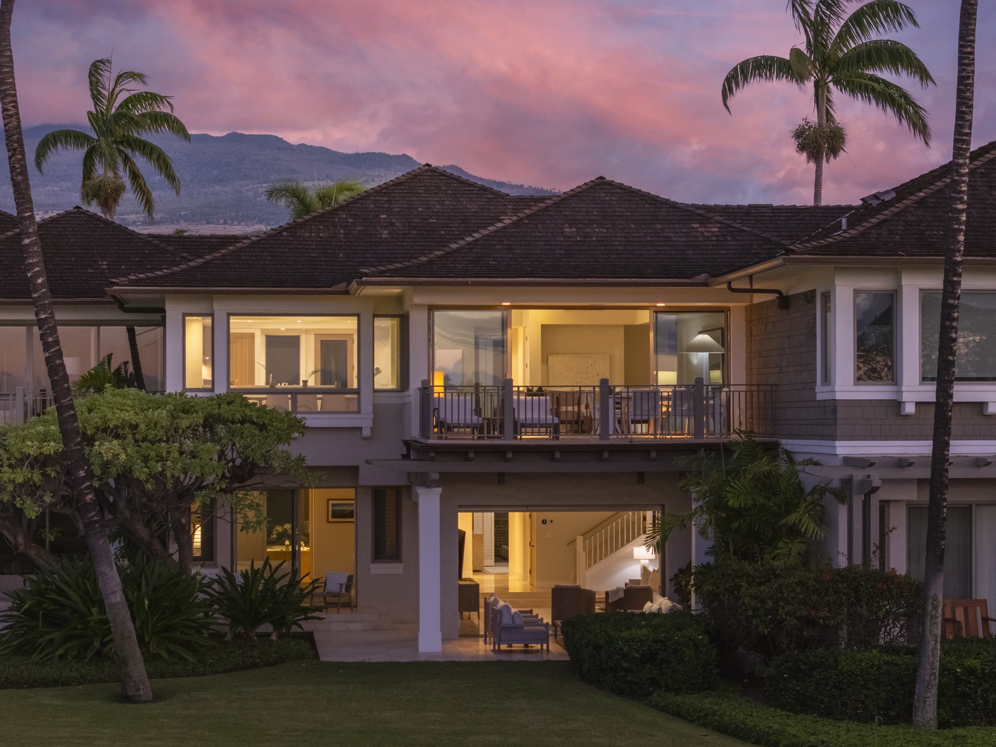 Kailua Kona Vacation Rentals, 3BD Palm Villa (130B) at Hualalai Resort - Tropical villa at dusk with mountain backdrop, palm trees, and warm interior lighting creating an inviting Hawaiian atmosphere.