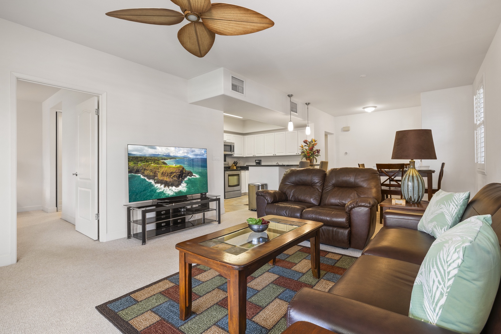 Relax in the open-concept living area with comfortable seating and easy access to the kitchen, dining area, and lanai.