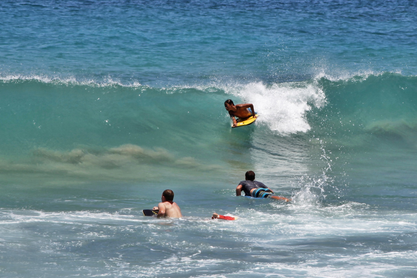 Koloa Vacation Rentals, Hale Kai'Opua - Boogie boarders riding the waves at Brennecke’s Beach, a hotspot for water fun.