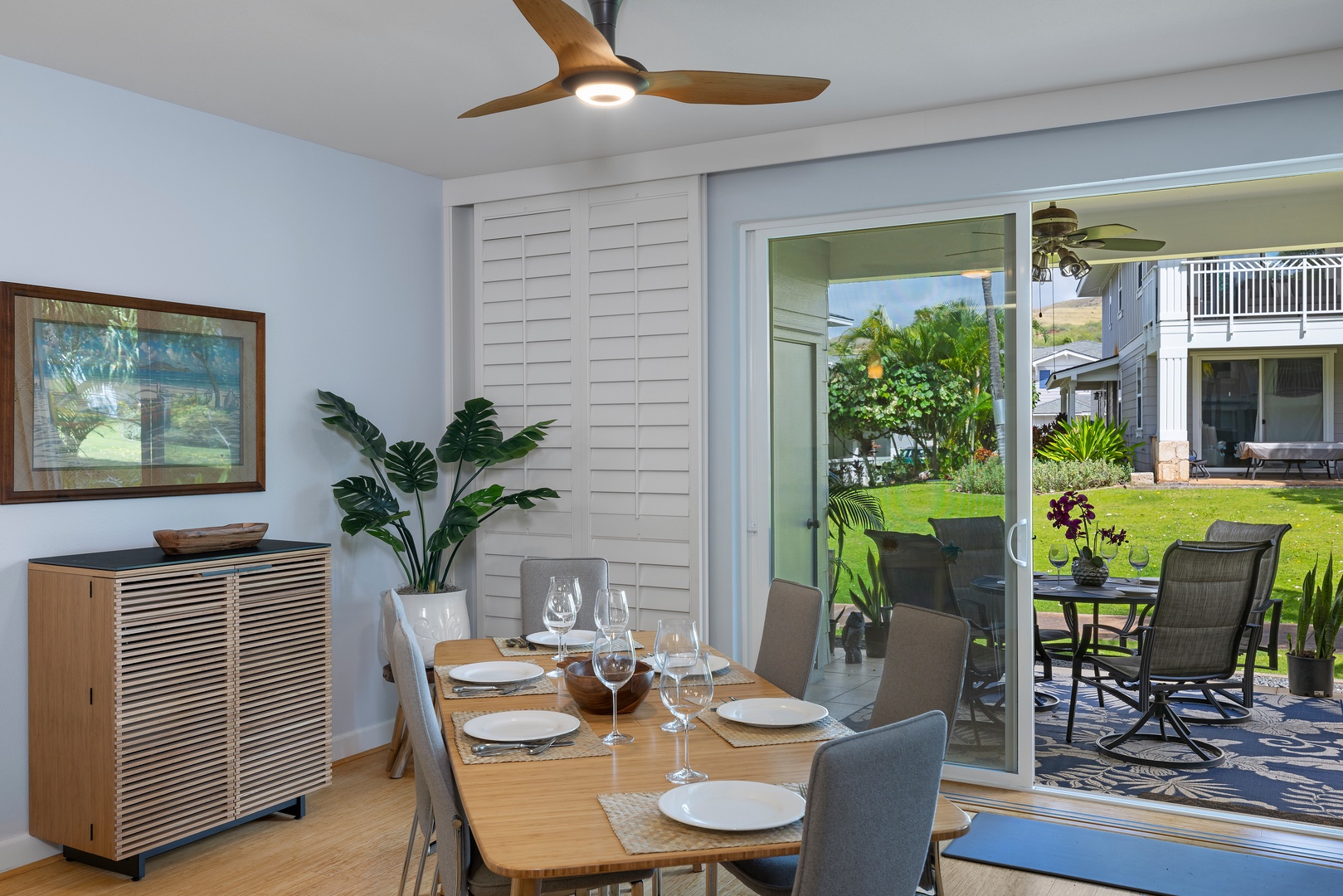 Gather around your elegant dining table where memorable meals await, with garden views through sliding doors.