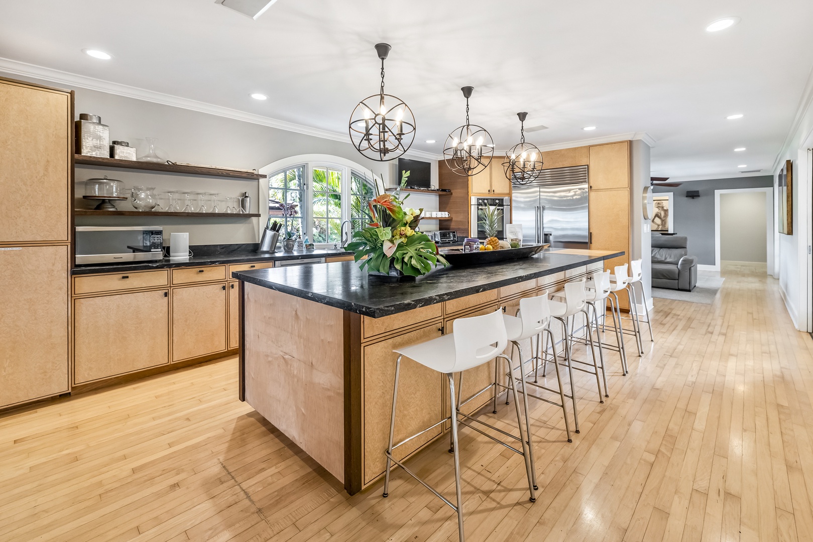 Honolulu Vacation Rentals, Moana Lani - Main House - Grab a stool at the long kitchen island while dinner comes together under the crystal pendants.
