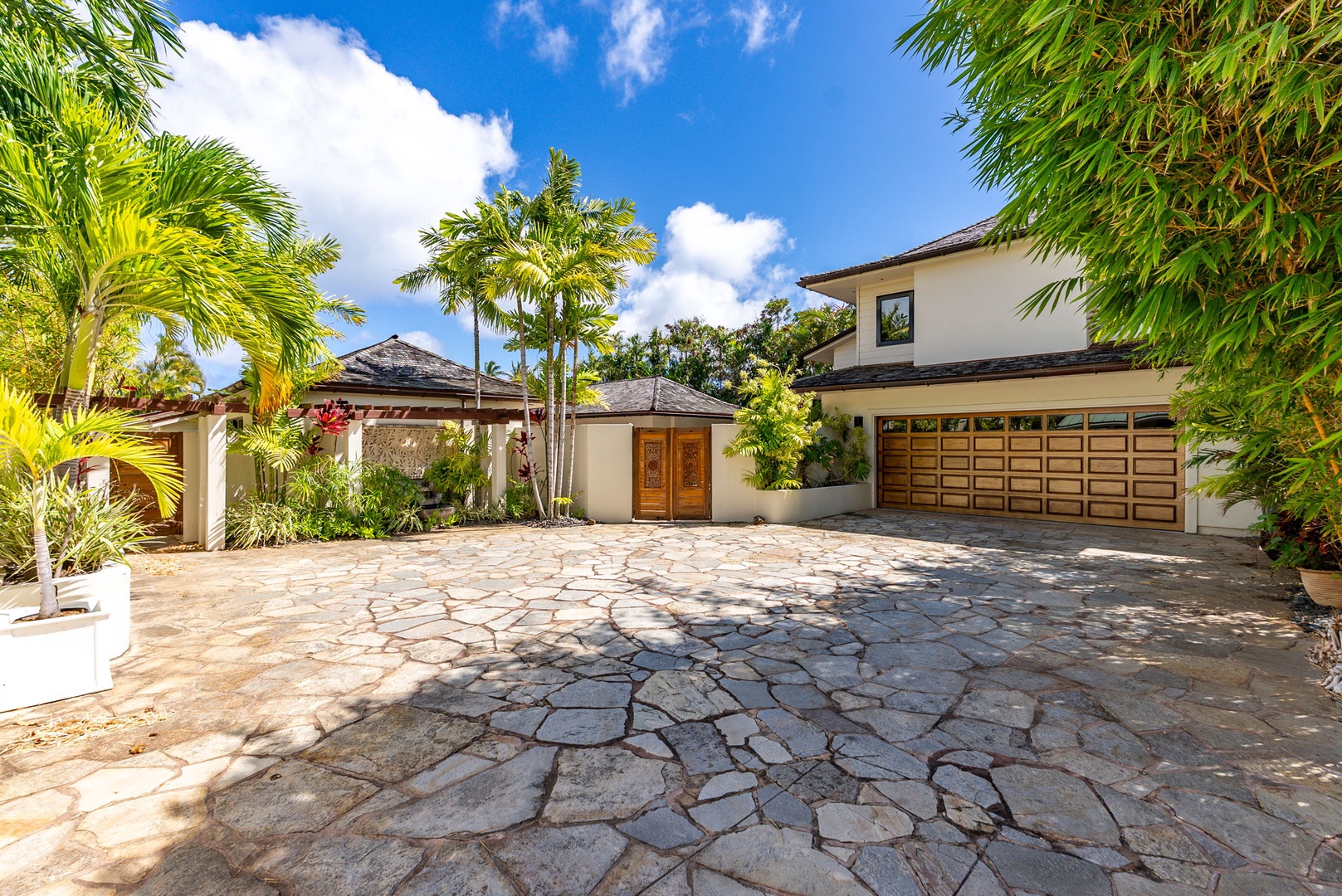 Honolulu Vacation Rentals, The Lagoon House 3BR - Villa exterior with palm-lined entry, stone driveway, and crisp island design.