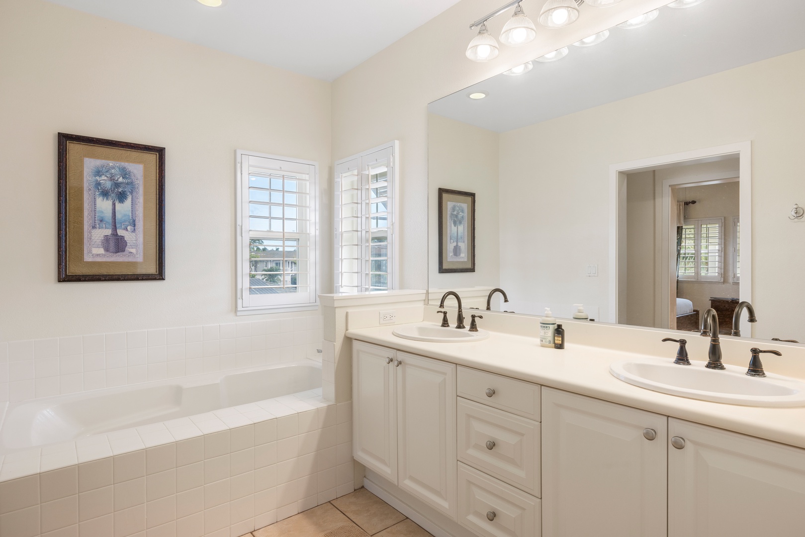 Kapolei Vacation Rentals, Coconut Plantation 1150-2 - Unwind in your elegant ensuite bathroom featuring a soaking tub, dual vanities, and abundant natural light for your perfect retreat.